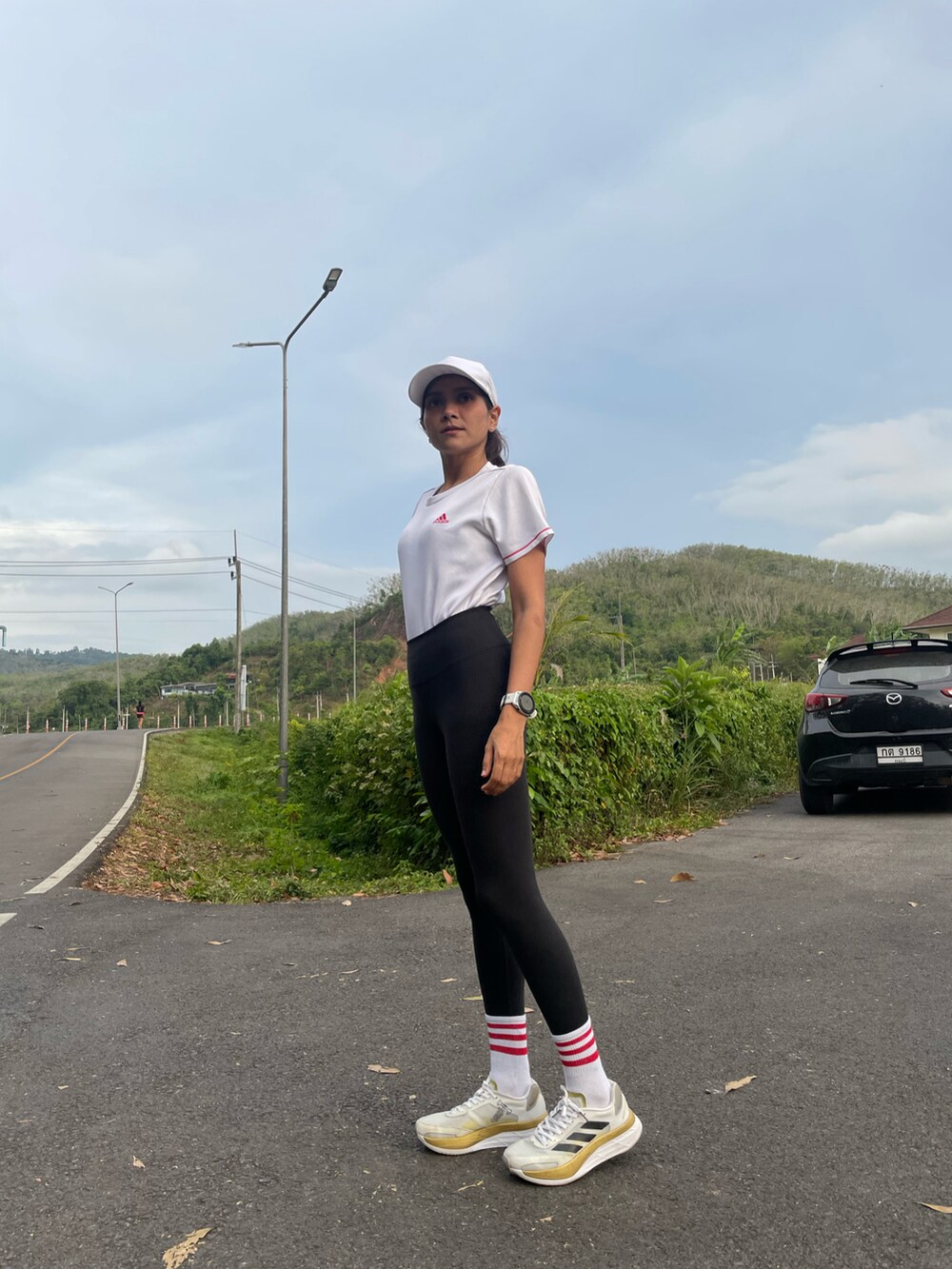 ホワイト系のスニーカー、ホワイト系のTシャツ/カットソー、ブラック系のスラックスを着用したレディースの春コーディネートの2枚目の写真
