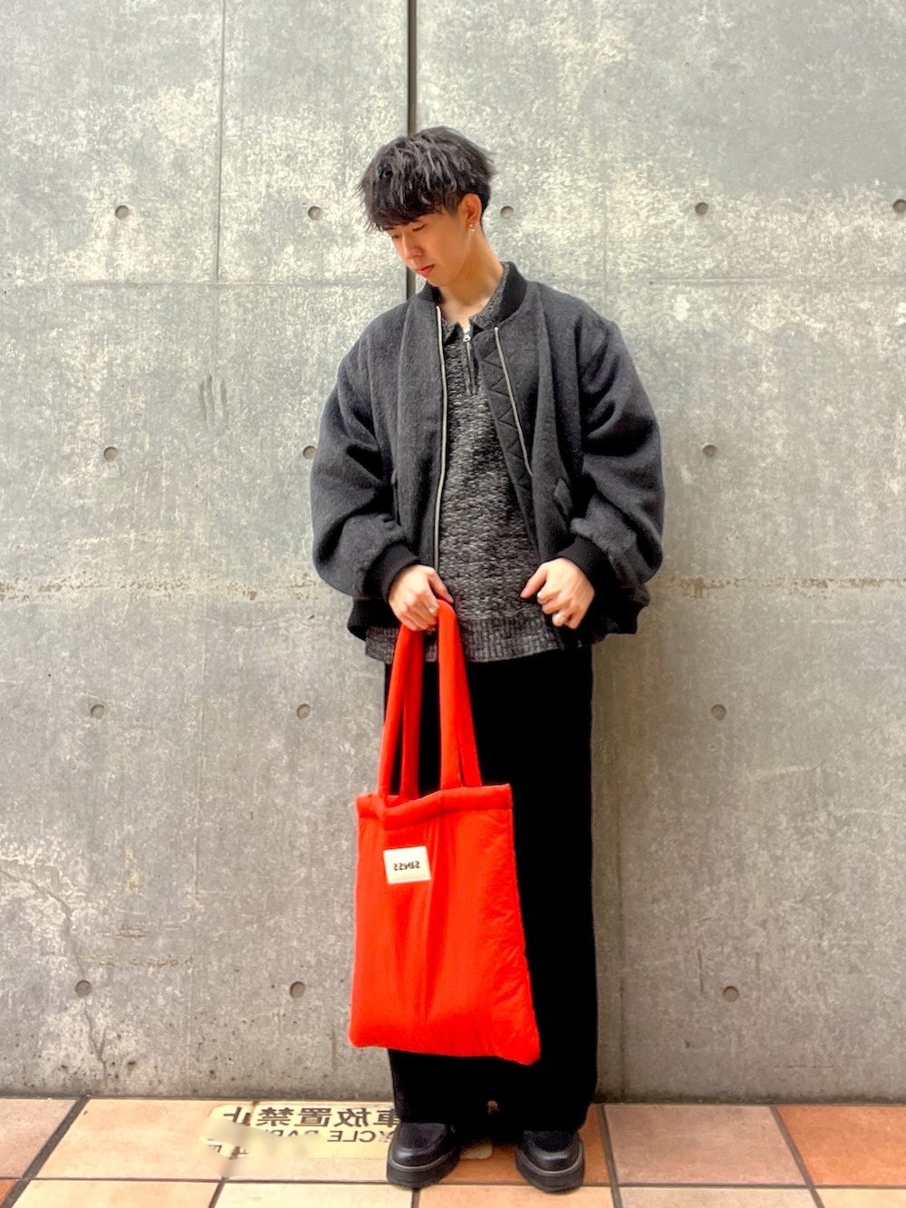 グレー系のMA-1、オレンジ系のトートバッグ、ブラック系のドレスシューズを着用したメンズの秋コーディネートの3枚目の写真