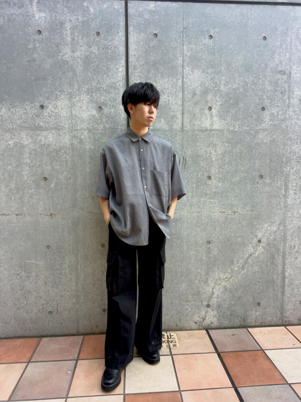 グレー系のシャツ/ブラウス、ブラック系のカーゴパンツ、ブラック系のドレスシューズを着用したメンズの春コーディネートの2枚目の写真