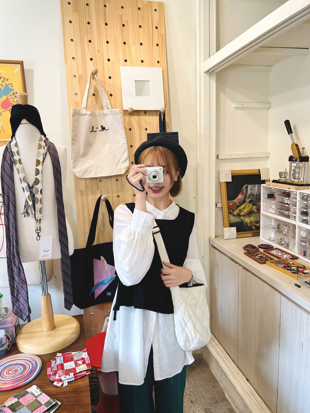 ブラック系のベスト、ホワイト系のシャツ/ブラウス、グリーン系のチノパンツを着用したレディースの春コーディネートの2枚目の写真