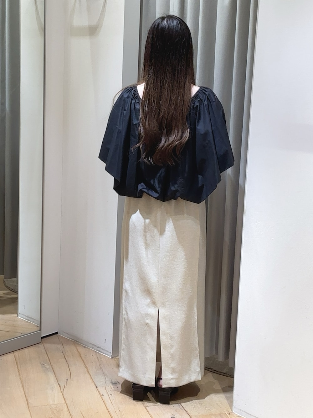 ブラック系のシャツ/ブラウス、ホワイト系のスカート、ブラック系のパンプスを着用したレディースの夏コーディネートの2枚目の写真