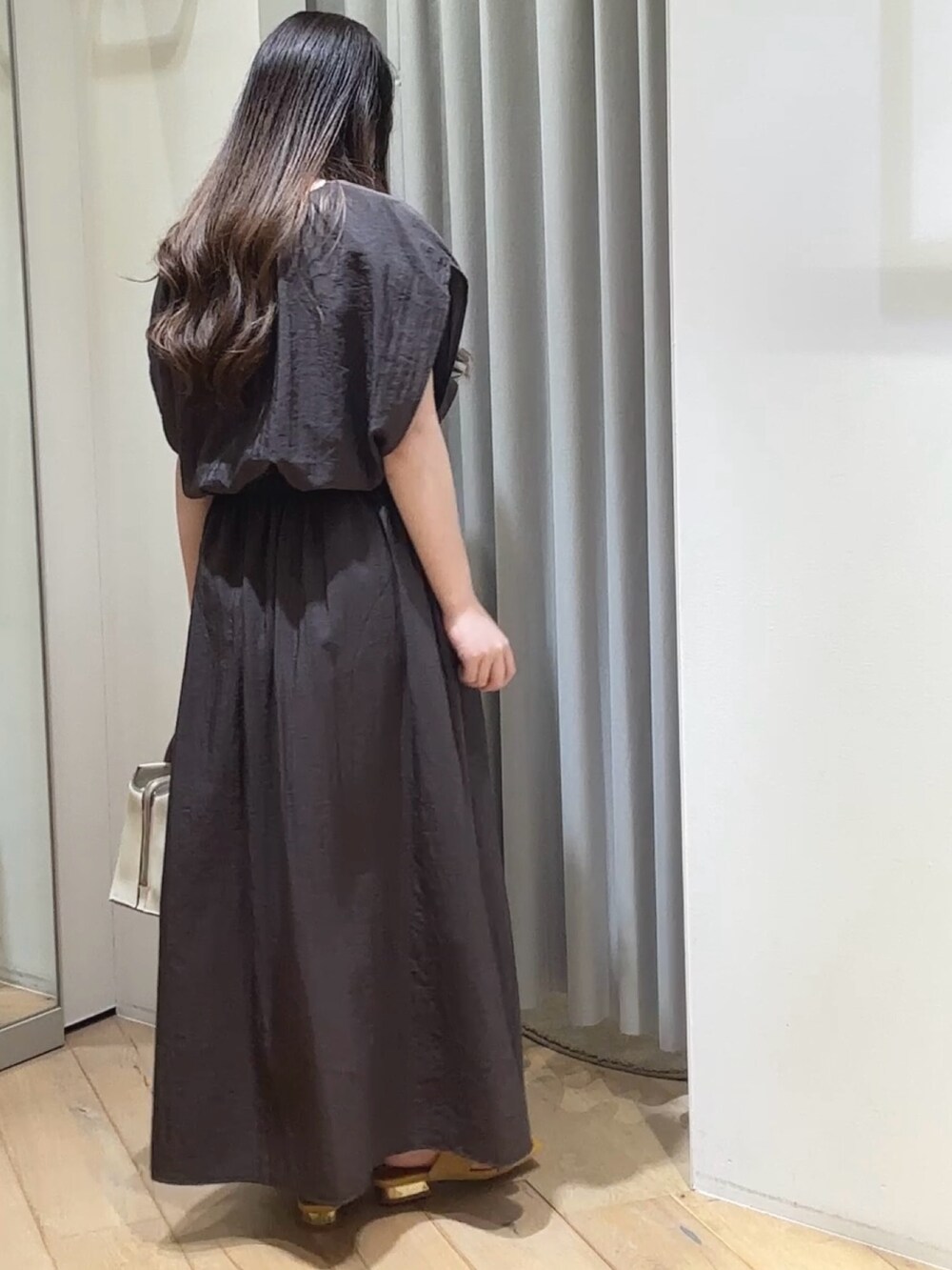 グレー系のワンピース、ホワイト系のショルダーバッグ、イエロー系のサンダルを着用したレディースの夏コーディネートの4枚目の写真