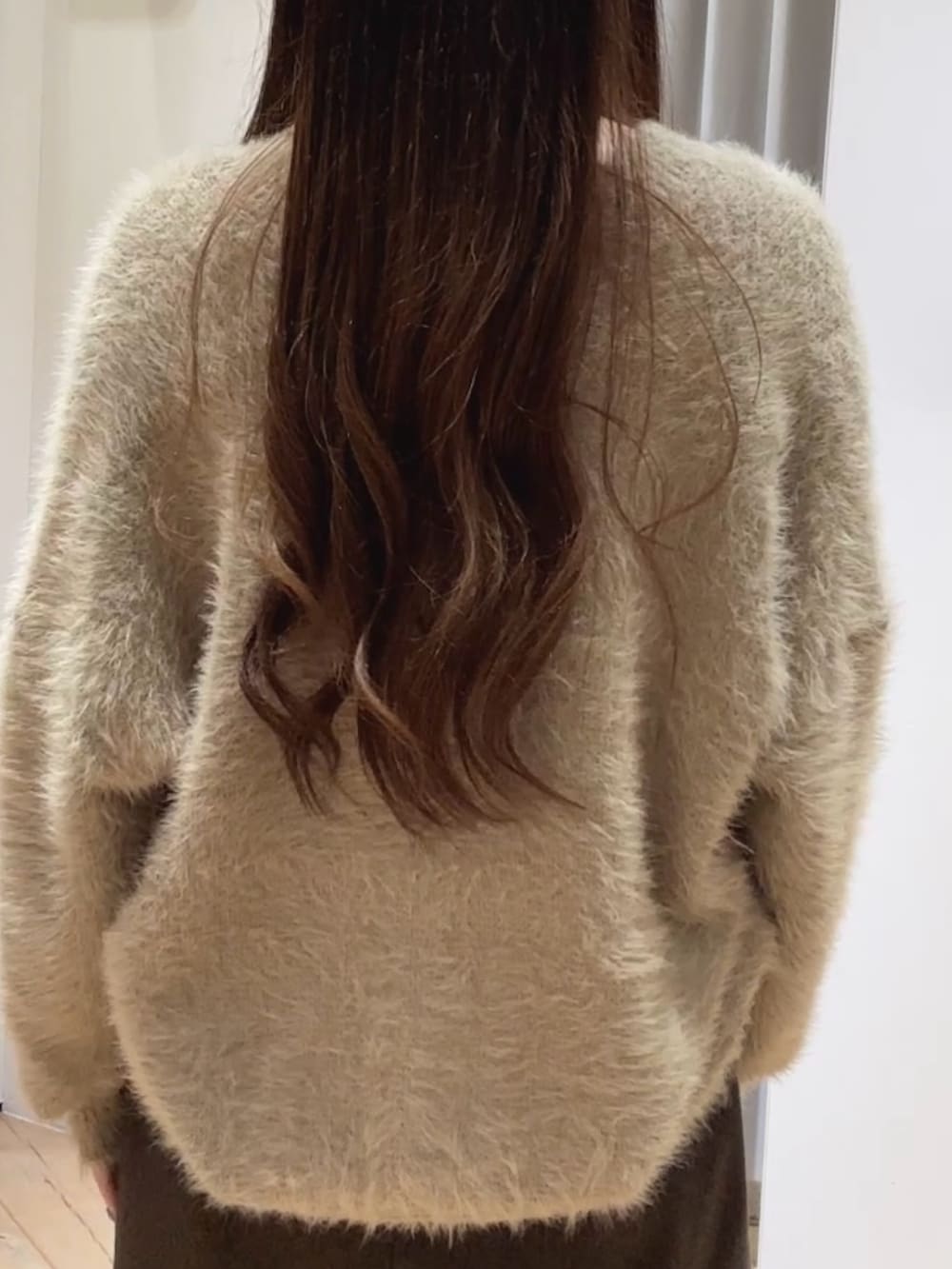 ブラウン系のスカート、ブラウン系のショルダーバッグ、ブラック系のブーツを着用したレディースの秋コーディネートの4枚目の写真