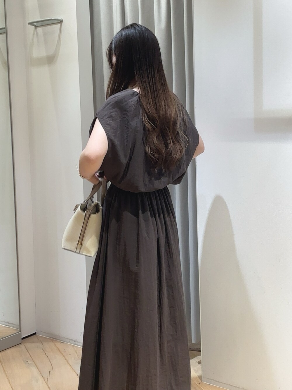 グレー系のワンピース、ホワイト系のショルダーバッグ、イエロー系のサンダルを着用したレディースの夏コーディネートの3枚目の写真