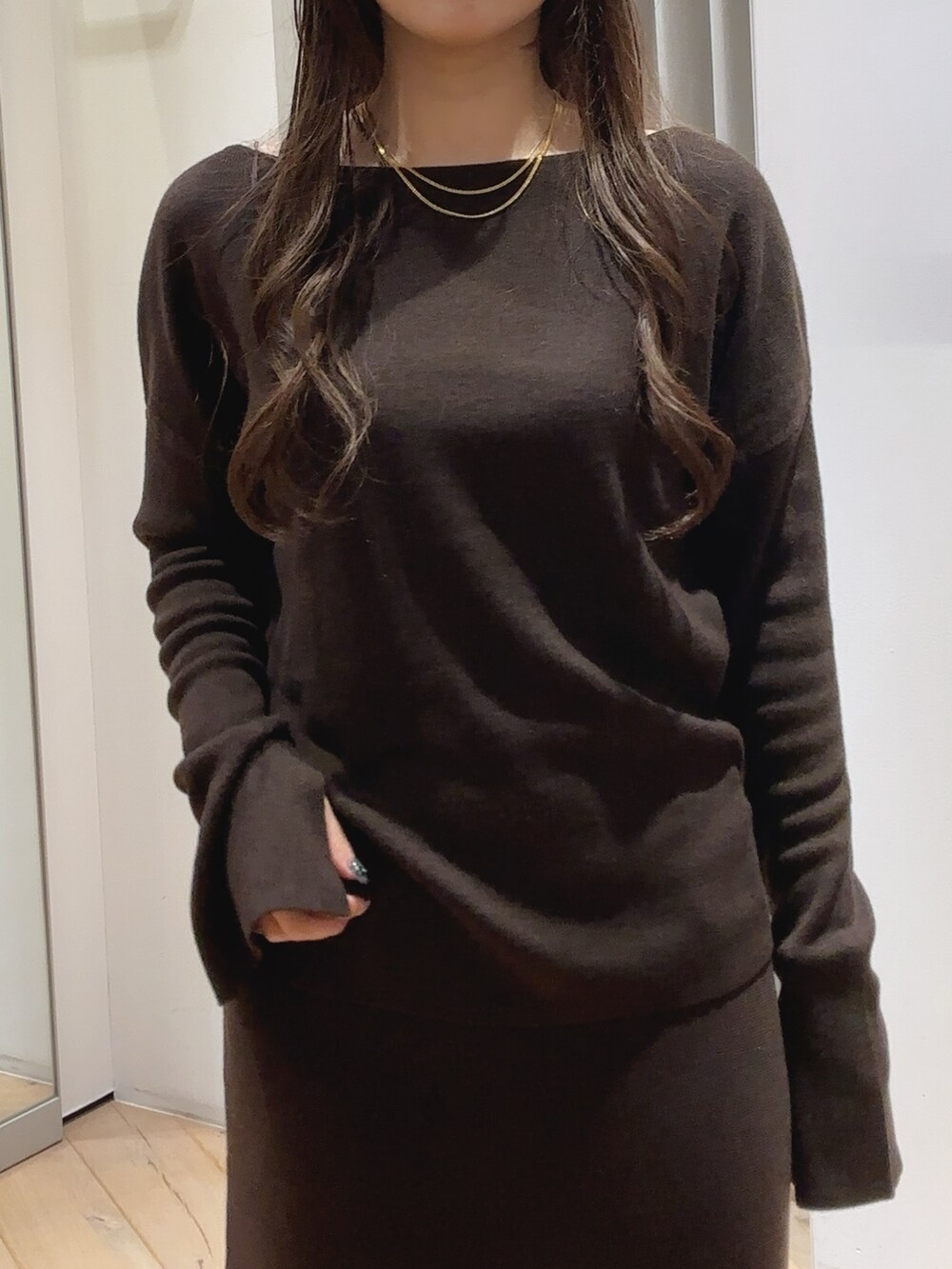 ブラウン系のショルダーバッグ、ブラウン系のニット/セーター、ブラウン系のスカートを着用したレディースの秋コーディネートの2枚目の写真