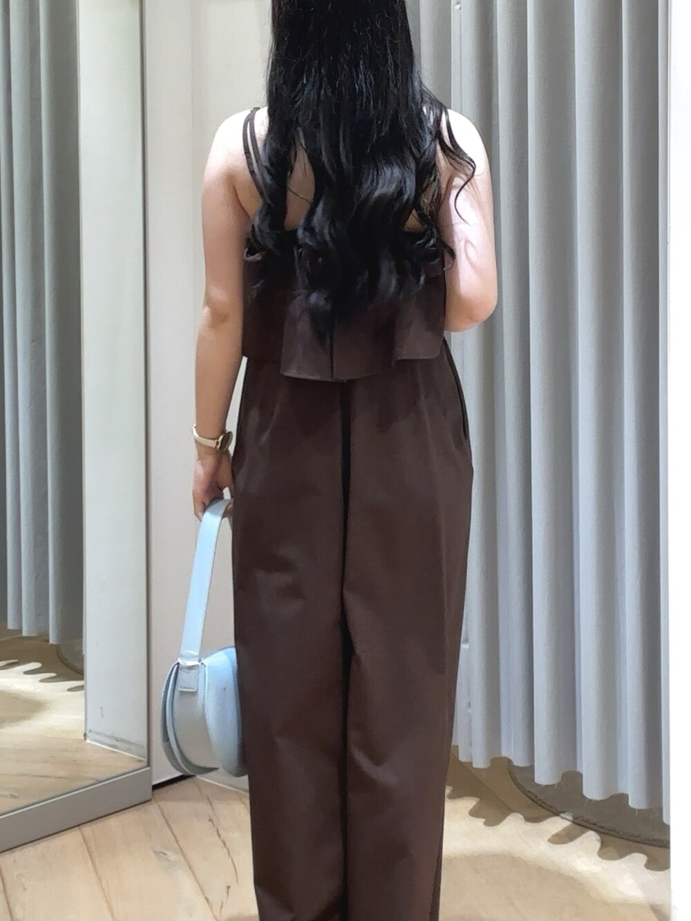 ブラウン系のサロペット/オーバーオール、ブルー系のショルダーバッグ、イエロー系のサンダルを着用したレディースの夏コーディネートの2枚目の写真