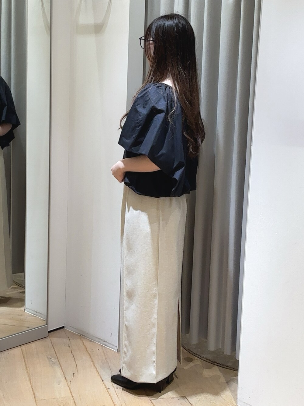 ブラック系のシャツ/ブラウス、ホワイト系のスカート、ブラック系のパンプスを着用したレディースの夏コーディネートの3枚目の写真