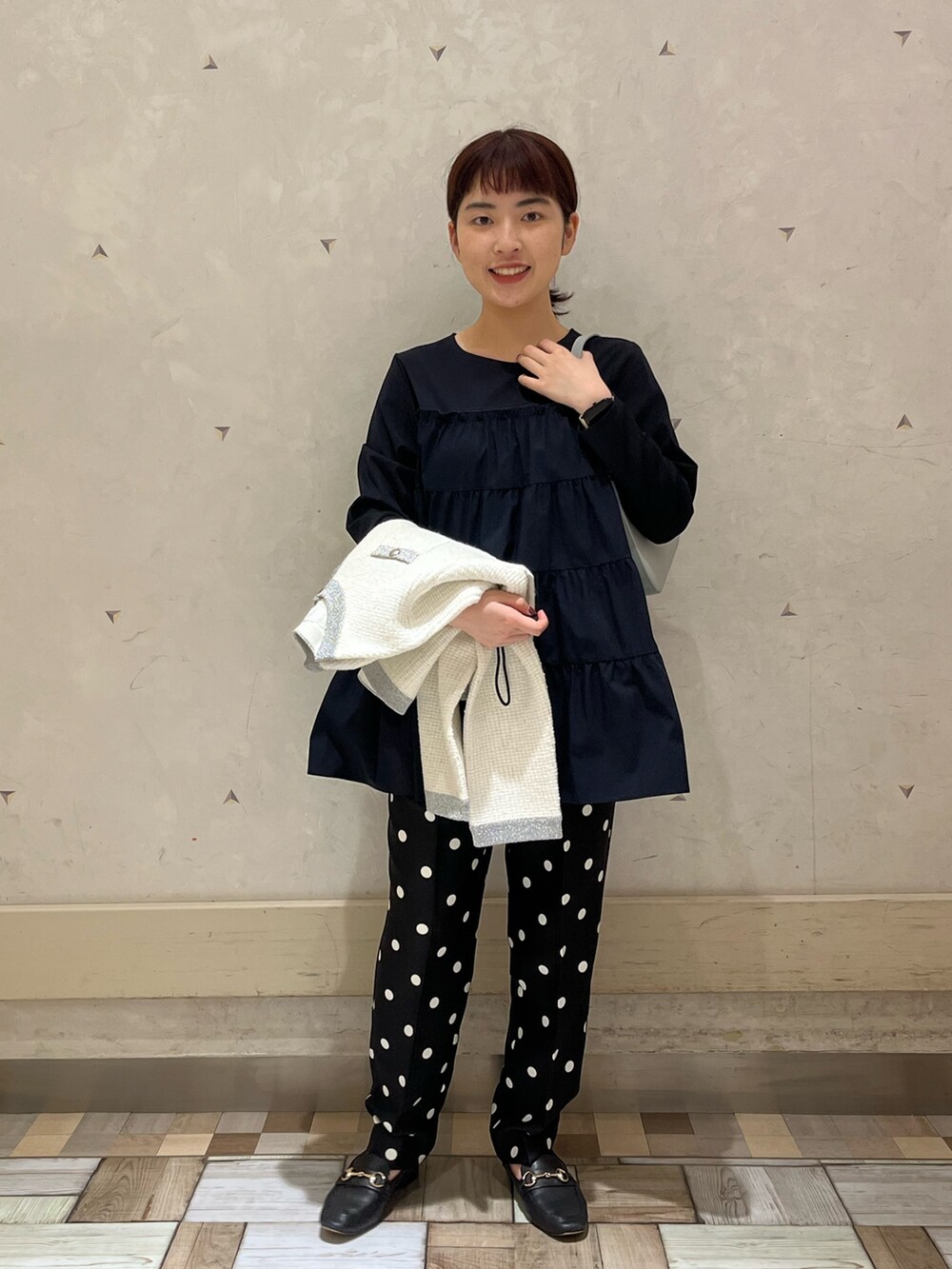 ホワイト系のカーディガン/ボレロ、ブルー系のTシャツ/カットソー、ブルー系のハンドバッグを着用したレディースの秋コーディネートの4枚目の写真