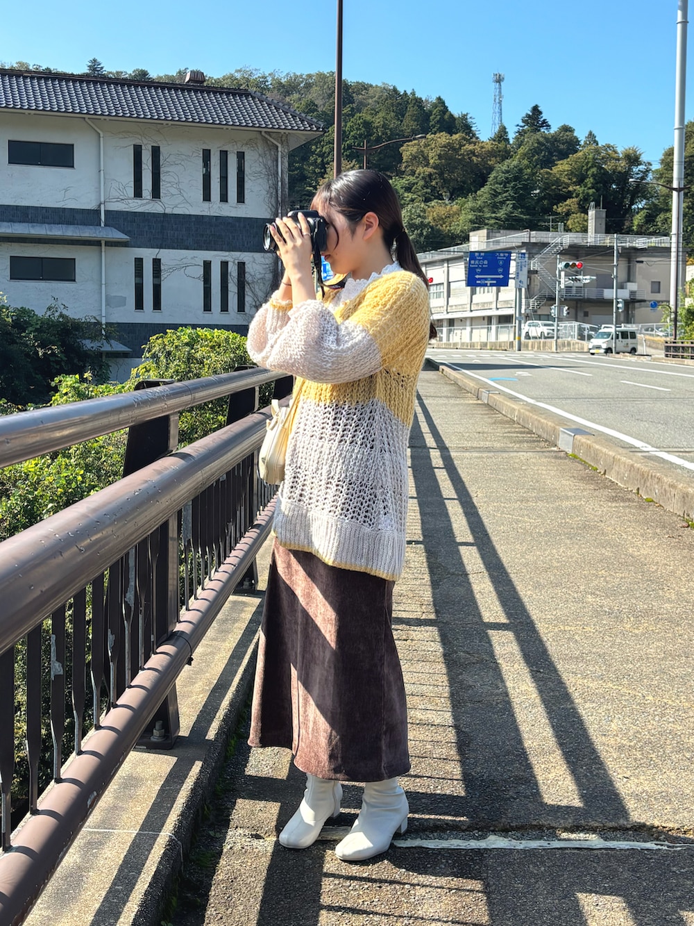 ブラウン系のワンピース、ホワイト系のブーツ、イエロー系のニット/セーターを着用したレディースの秋コーディネートの2枚目の写真