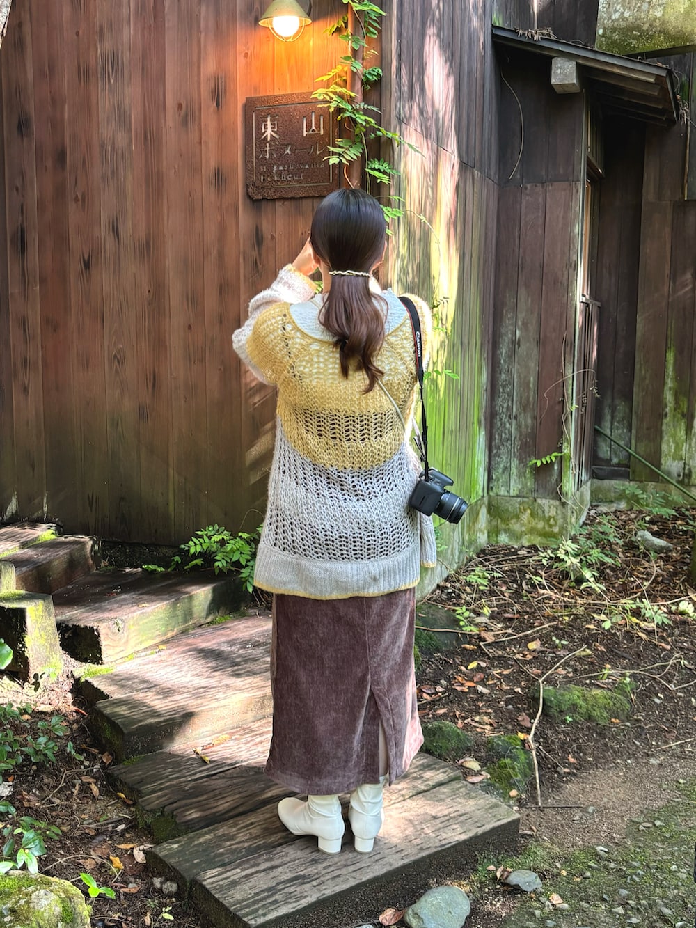 ブラウン系のワンピース、ホワイト系のブーツ、イエロー系のニット/セーターを着用したレディースの秋コーディネートの3枚目の写真