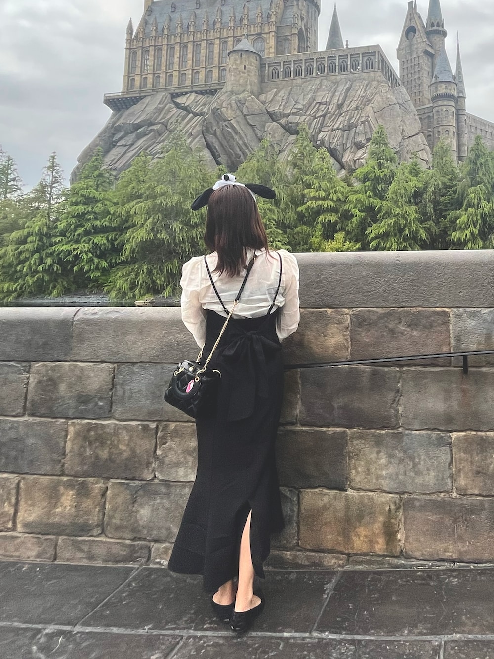 ブラック系のワンピース、ホワイト系のシャツ/ブラウス、ブラック系のショルダーバッグを着用したレディースの春コーディネートの3枚目の写真