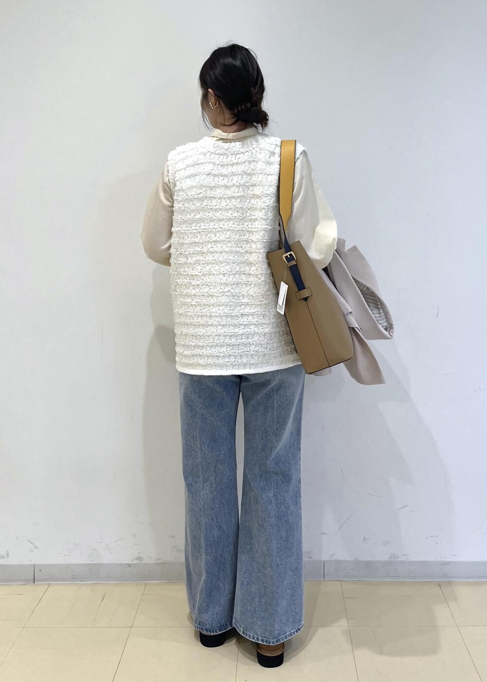 イエロー系のトートバッグ、ベージュ系のローファー、ベージュ系のテーラードジャケットを着用したレディースの冬コーディネートの10枚目の写真