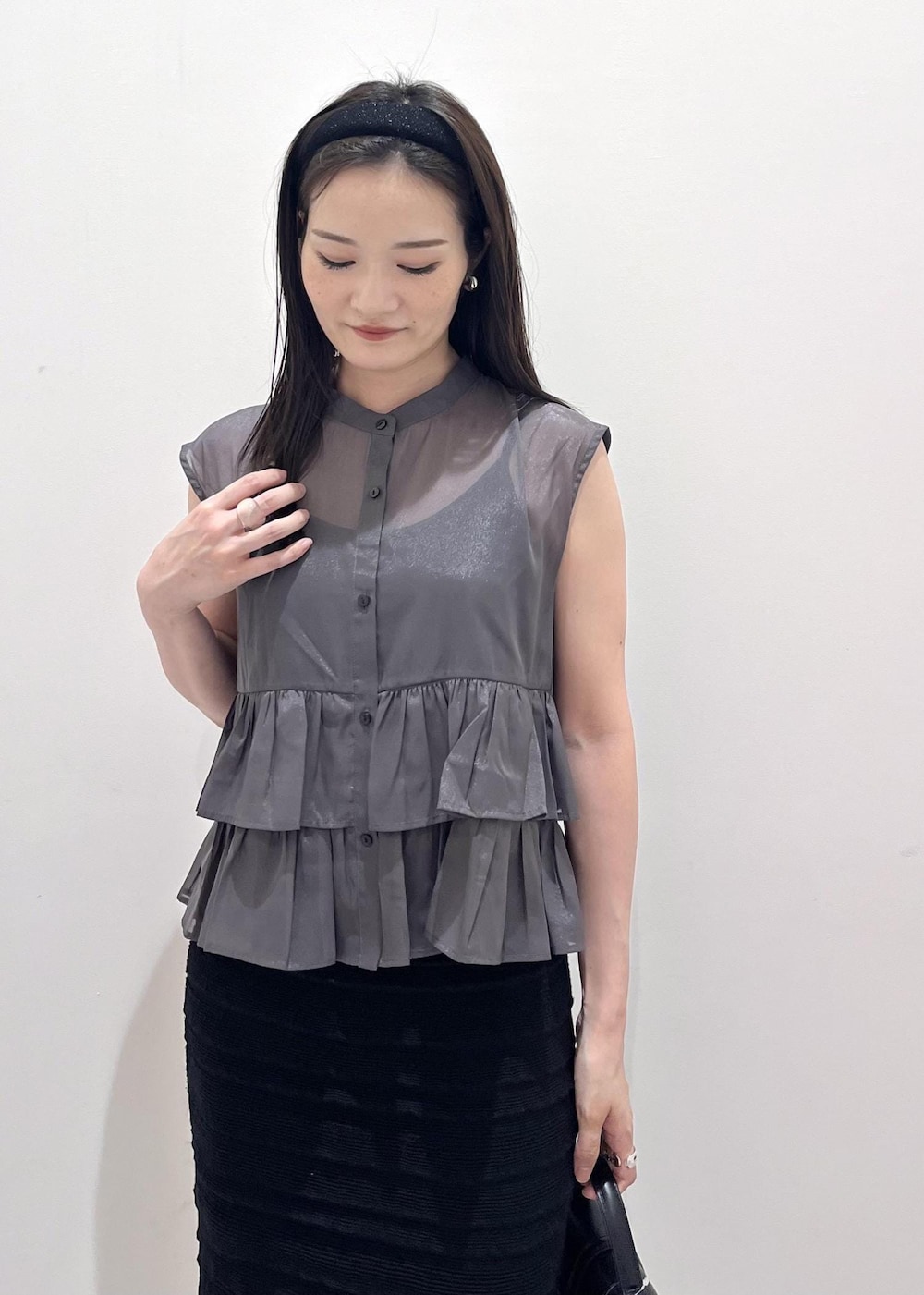 ブラック系のスカート、グレー系のシャツ/ブラウス、ブラック系のショルダーバッグを着用したレディースの夏コーディネートの2枚目の写真