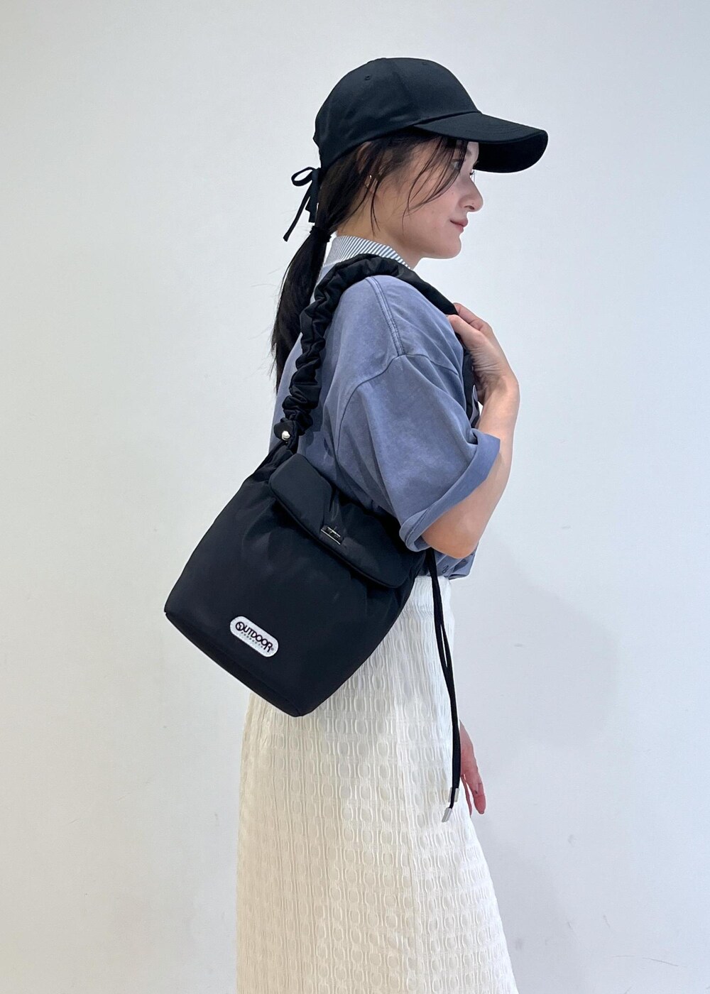 ブラック系のサンダル、ホワイト系のスカート、ブルー系のシャツ/ブラウスを着用したレディースの夏コーディネートの7枚目の写真