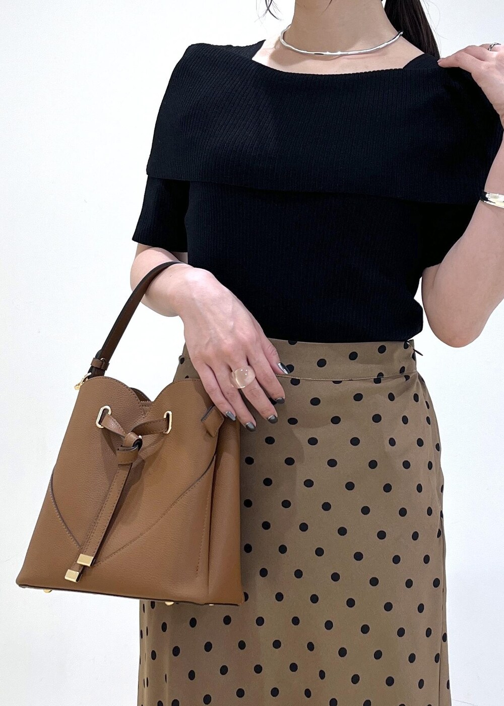 ブラック系のサンダル、ブラウン系のショルダーバッグ、ブラウン系のスカートを着用したレディースの夏コーディネートの7枚目の写真