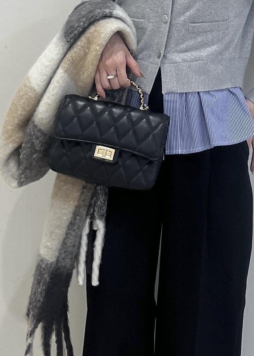 ホワイト系のパンプス、グレー系のカーディガン/ボレロ、ブラック系のスラックスを着用したレディースの冬コーディネートの9枚目の写真