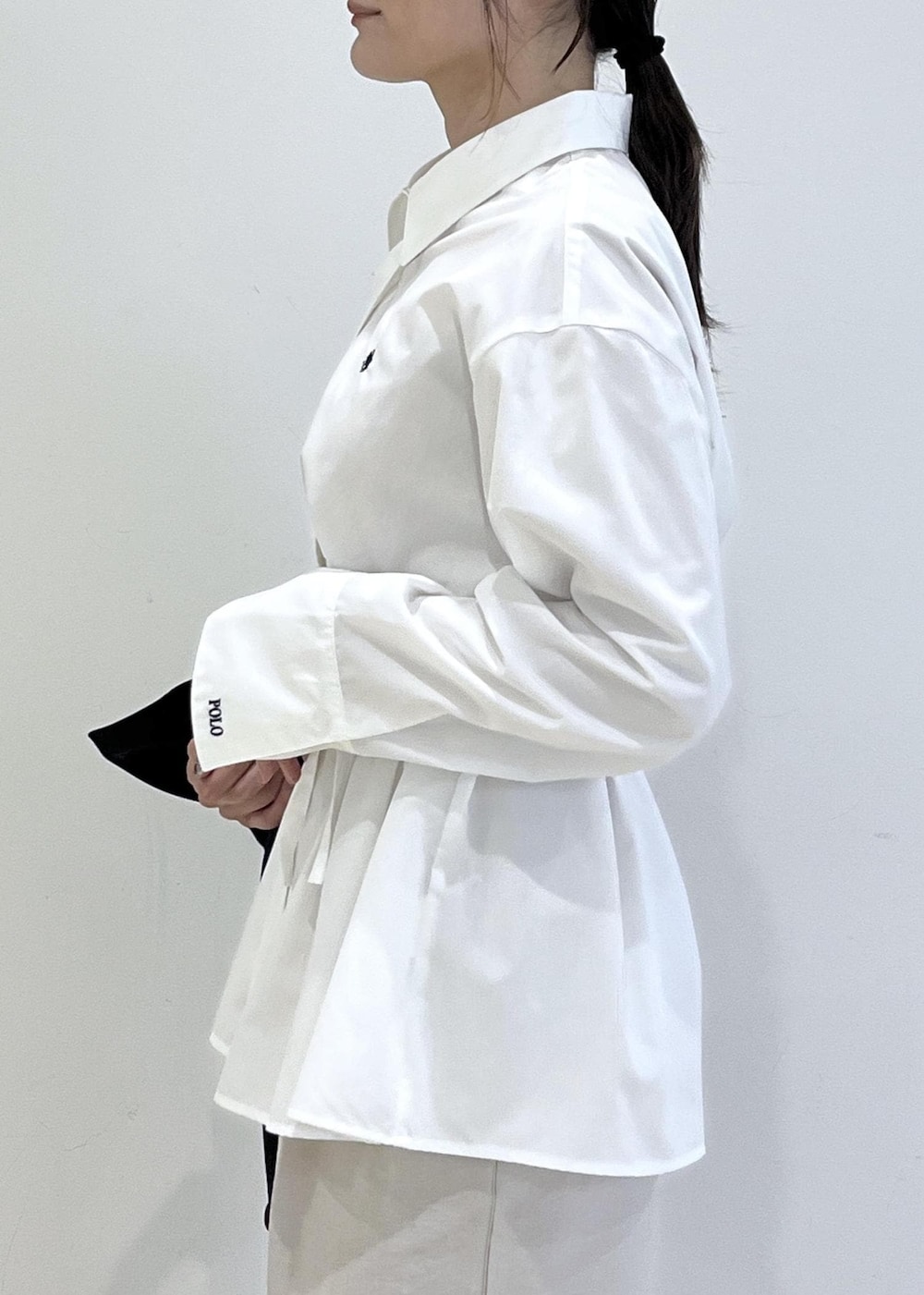 ブラック系のパンプス、ベージュ系のショルダーバッグ、ブルー系のトレンチコートを着用したレディースの春コーディネートの6枚目の写真