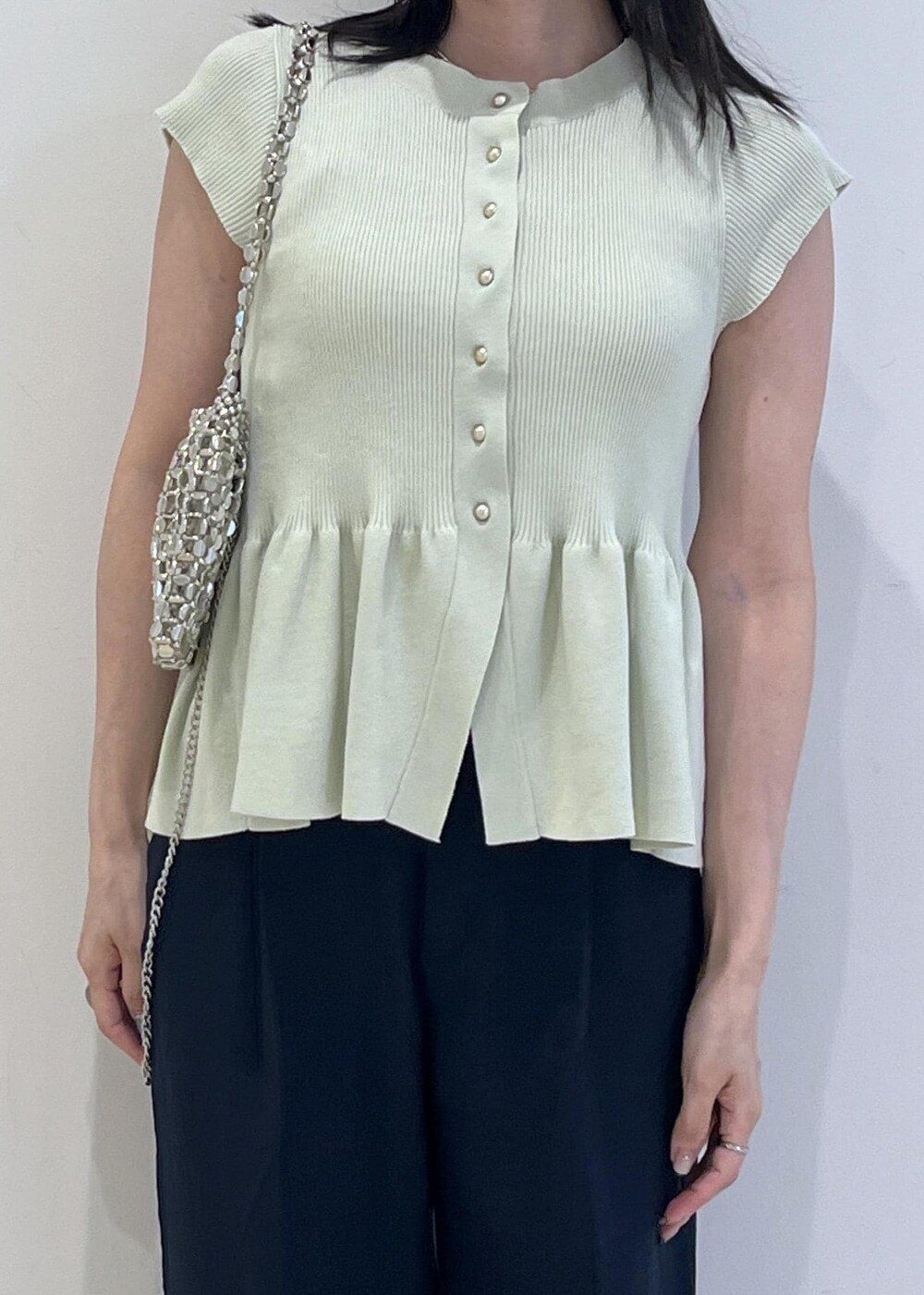 シルバー系のパンプス、シルバー系のハンドバッグ、ブルー系のスラックスを着用したレディースの夏コーディネートの9枚目の写真