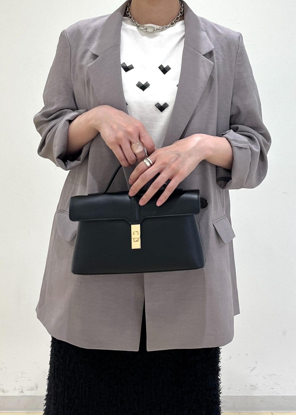 ホワイト系のTシャツ/カットソー、グレー系のテーラードジャケット、ブラック系のサンダルを着用したレディースの夏コーディネートの7枚目の写真