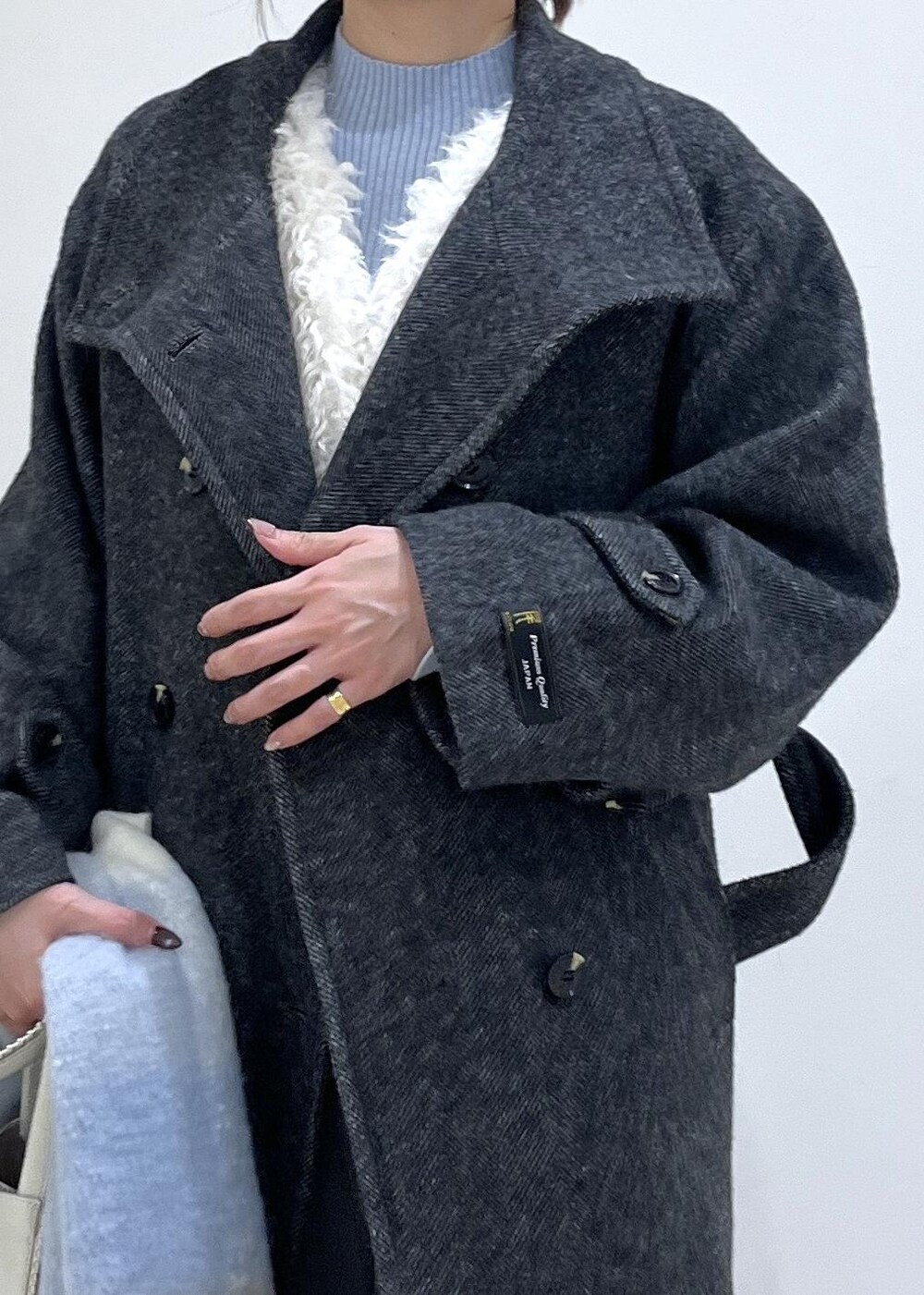 グレー系のスラックス、ホワイト系のベスト、ブルー系のニット/セーターを着用したレディースの秋コーディネートの6枚目の写真