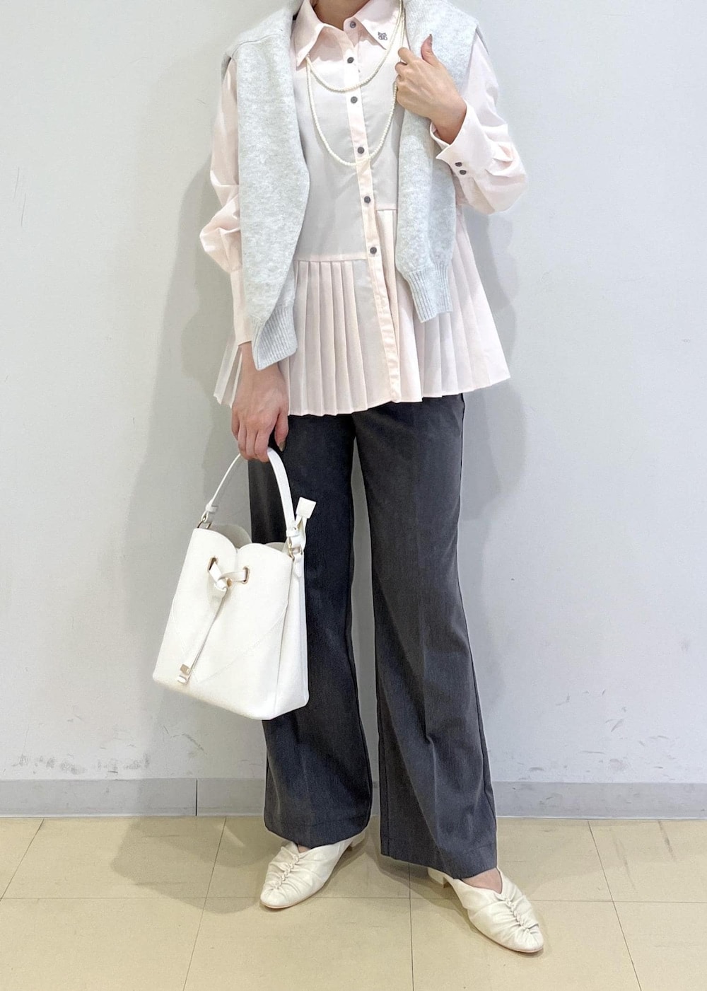 ホワイト系のショルダーバッグ、ホワイト系のパンプス、グレー系のスラックスを着用したレディースの秋コーディネートの10枚目の写真