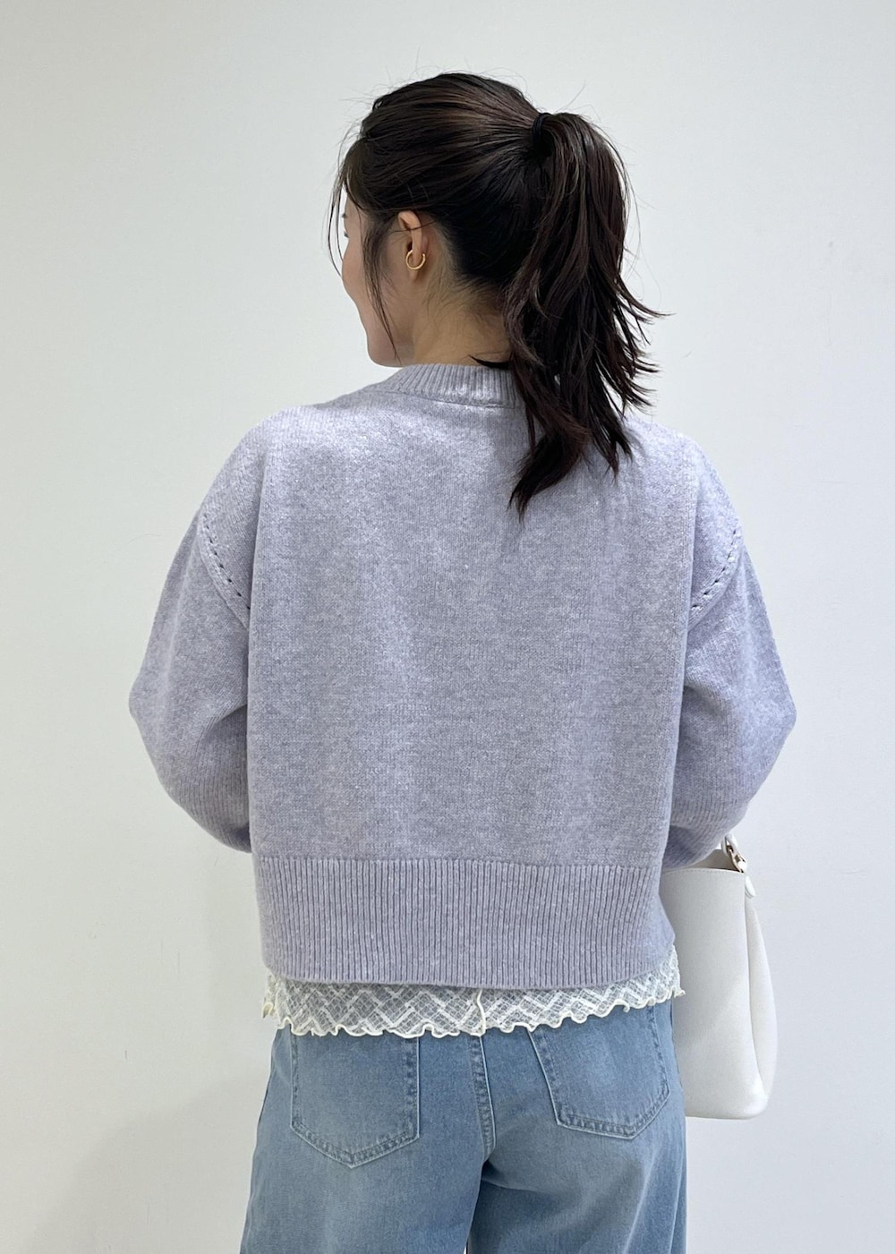 ホワイト系のショルダーバッグ、ホワイト系のパンプス、パープル系のカーディガン/ボレロを着用したレディースの秋コーディネートの9枚目の写真