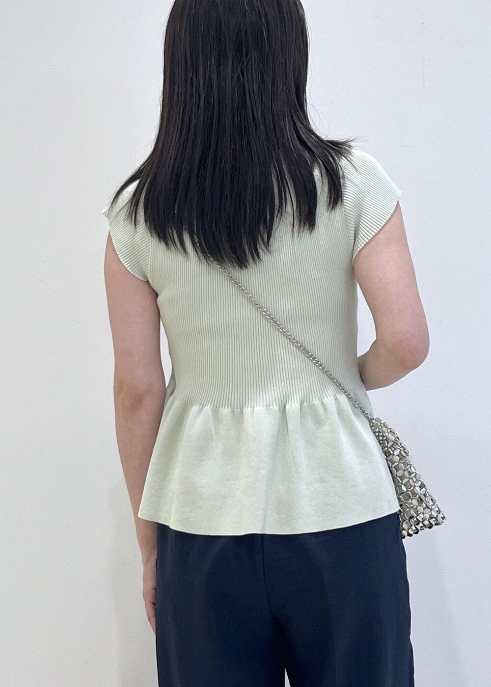 シルバー系のパンプス、シルバー系のハンドバッグ、ブルー系のスラックスを着用したレディースの夏コーディネートの6枚目の写真