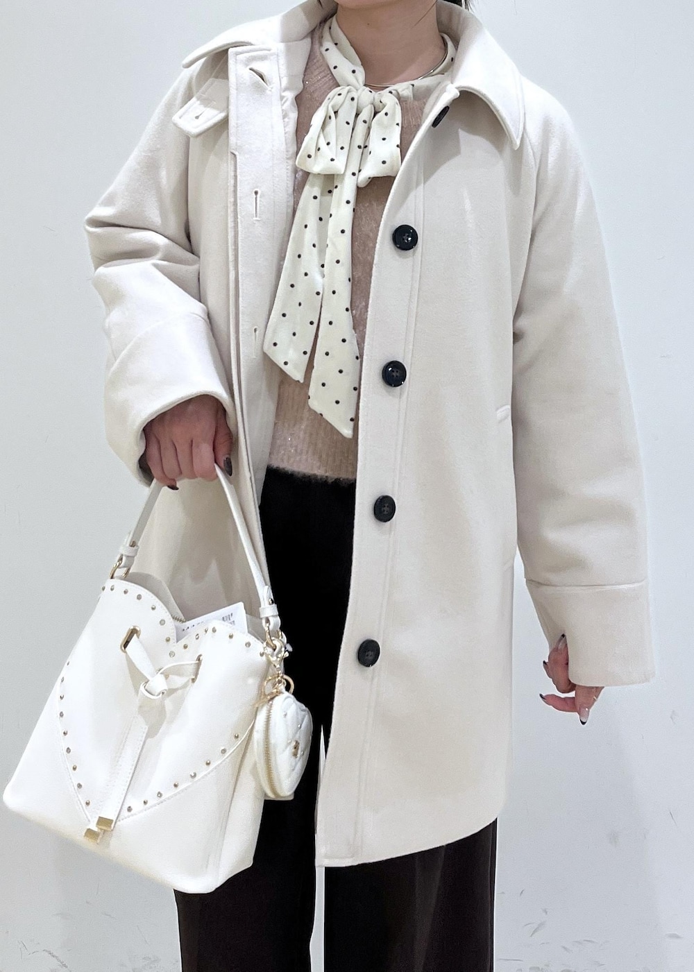 ブラウン系のスラックス、ベージュ系のチェスターコート、ベージュ系のブーツを着用したレディースの冬コーディネートの10枚目の写真