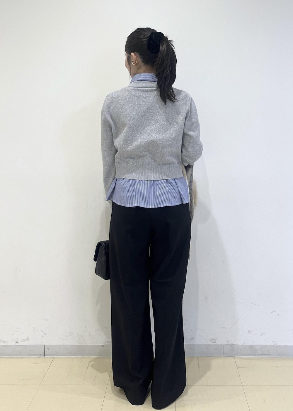 ホワイト系のパンプス、グレー系のカーディガン/ボレロ、ブラック系のスラックスを着用したレディースの冬コーディネートの2枚目の写真