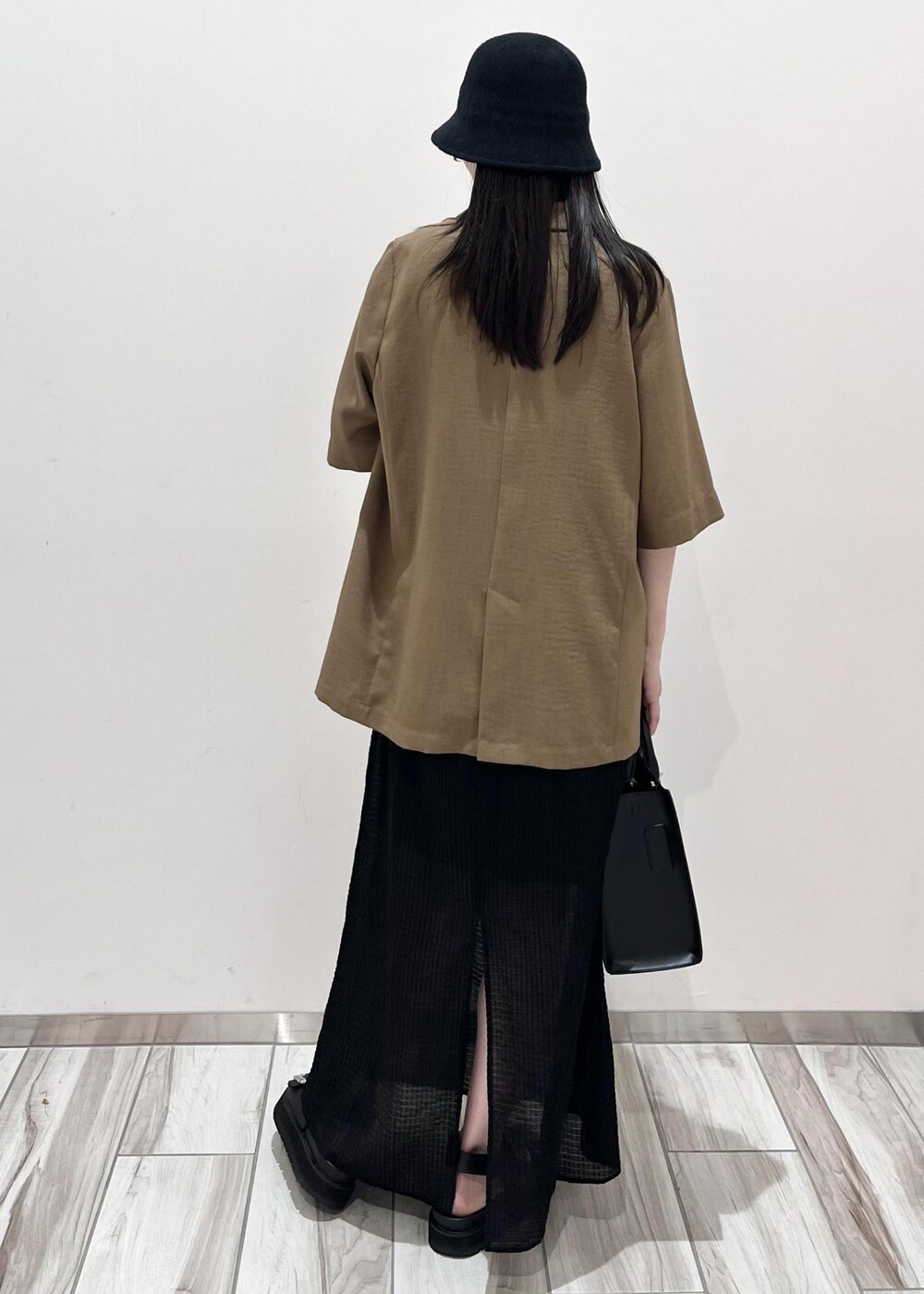 ブラック系のサンダル、ブラック系のハンドバッグ、ブラウン系のテーラードジャケットを着用したレディースの夏コーディネートの7枚目の写真