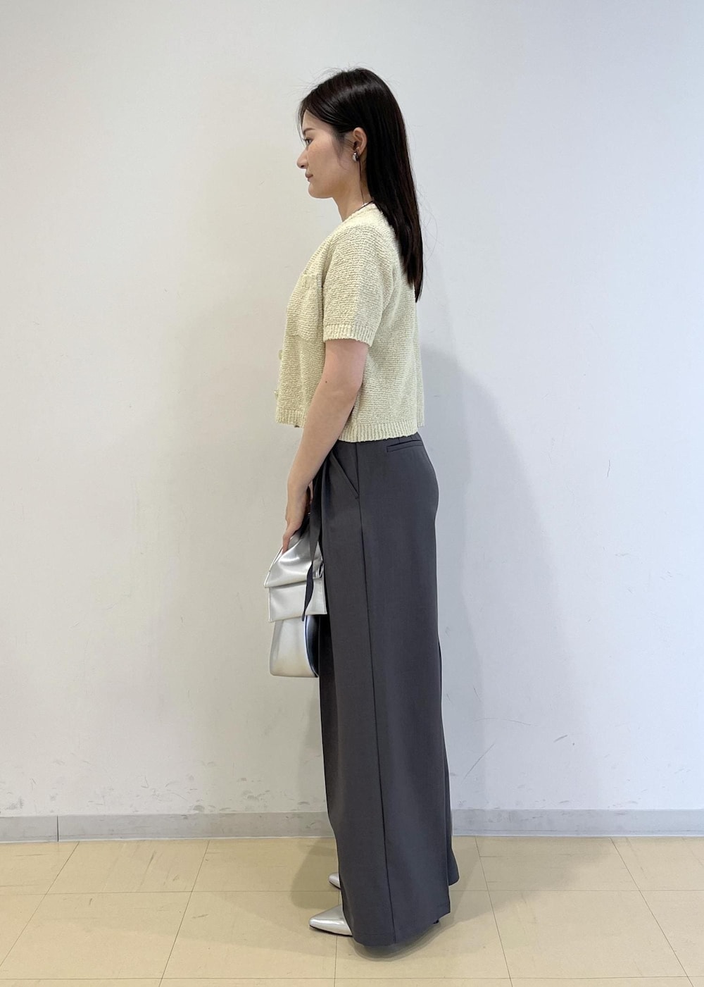 シルバー系のハンドバッグ、シルバー系のパンプス、グリーン系のカーディガン/ボレロを着用したレディースの春コーディネートの3枚目の写真