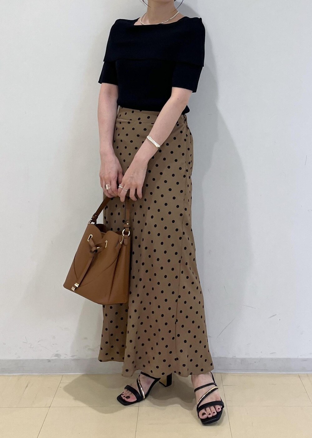 ブラック系のサンダル、ブラウン系のショルダーバッグ、ブラウン系のスカートを着用したレディースの夏コーディネートの10枚目の写真