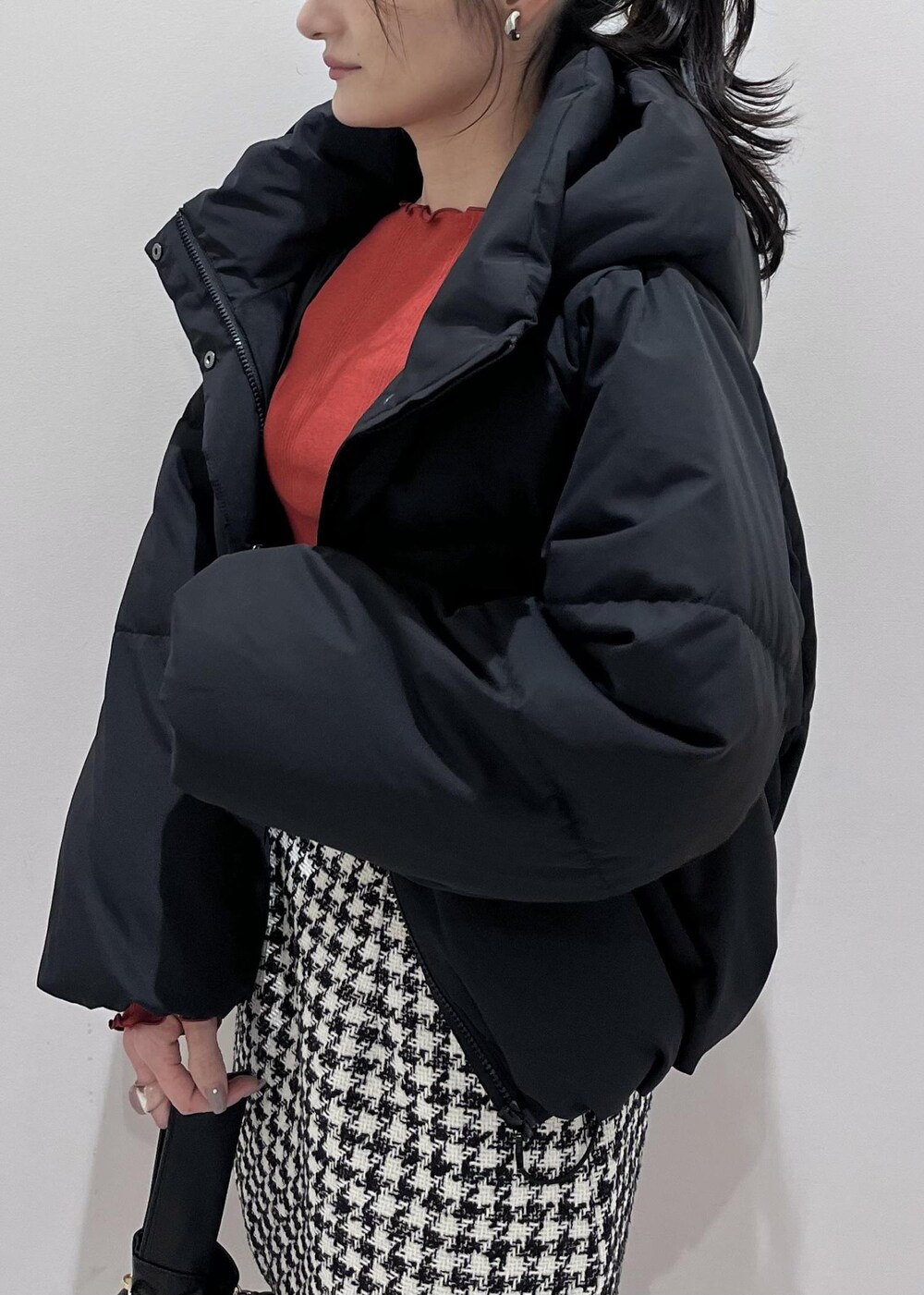 ブラック系のブーツ、ブラック系のスカート、ブラック系のダウンジャケット/コートを着用したレディースの冬コーディネートの5枚目の写真