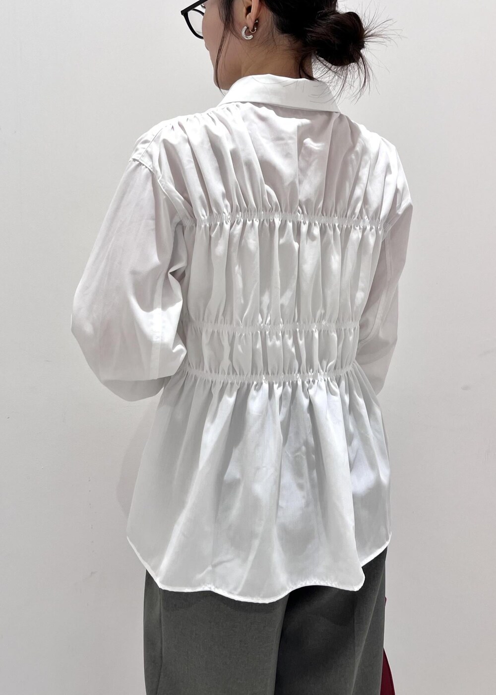 レッド系のトートバッグ、ブラック系のブーツ、ブラック系のカーディガン/ボレロを着用したレディースの秋コーディネートの8枚目の写真