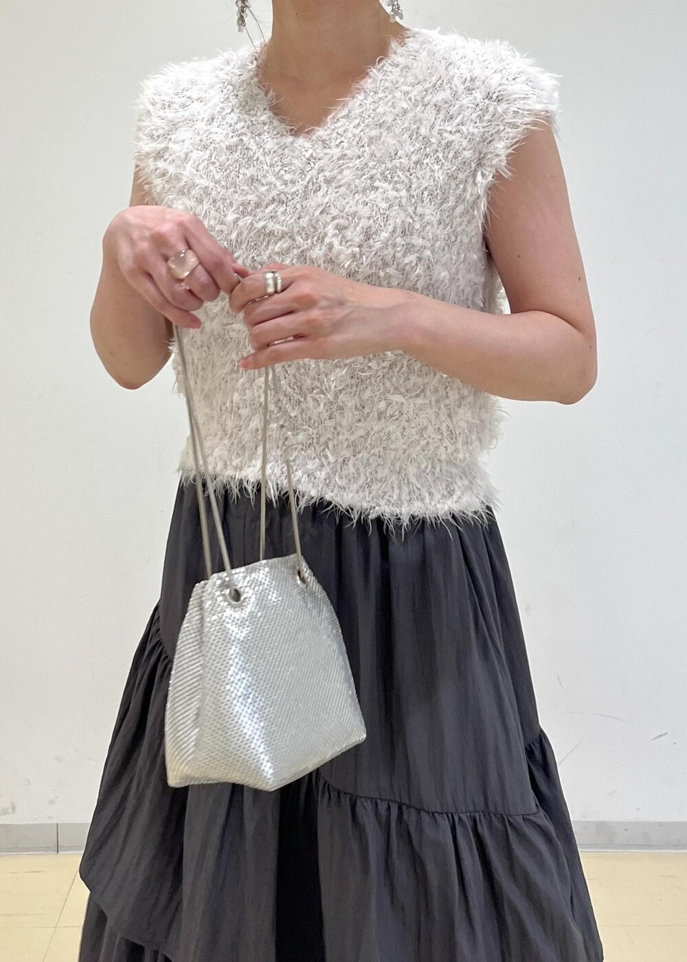 シルバー系のパンプス、シルバー系のショルダーバッグ、グレー系のスカートを着用したレディースの夏コーディネートの7枚目の写真