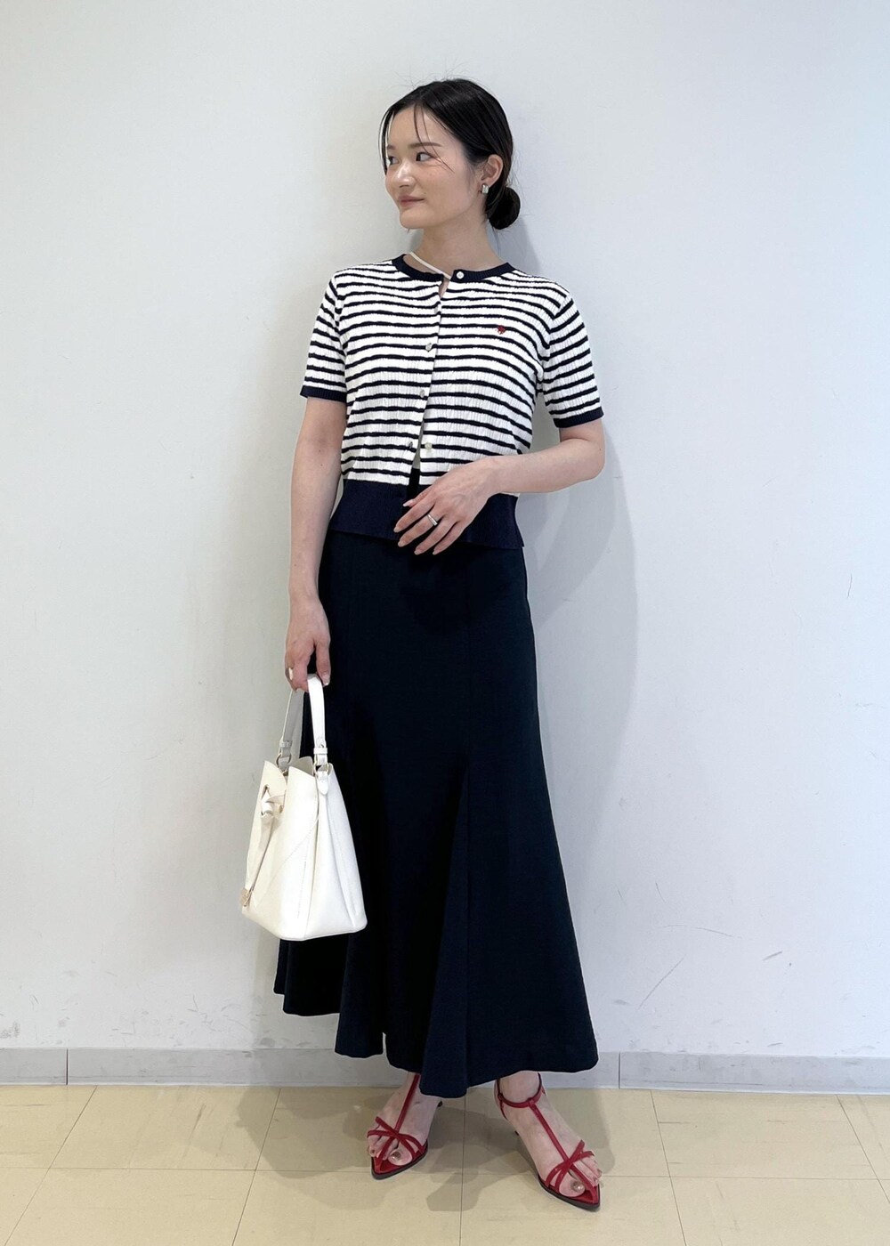 ホワイト系のショルダーバッグ、ホワイト系のキャミソール、レッド系のサンダルを着用したレディースの春コーディネートの2枚目の写真