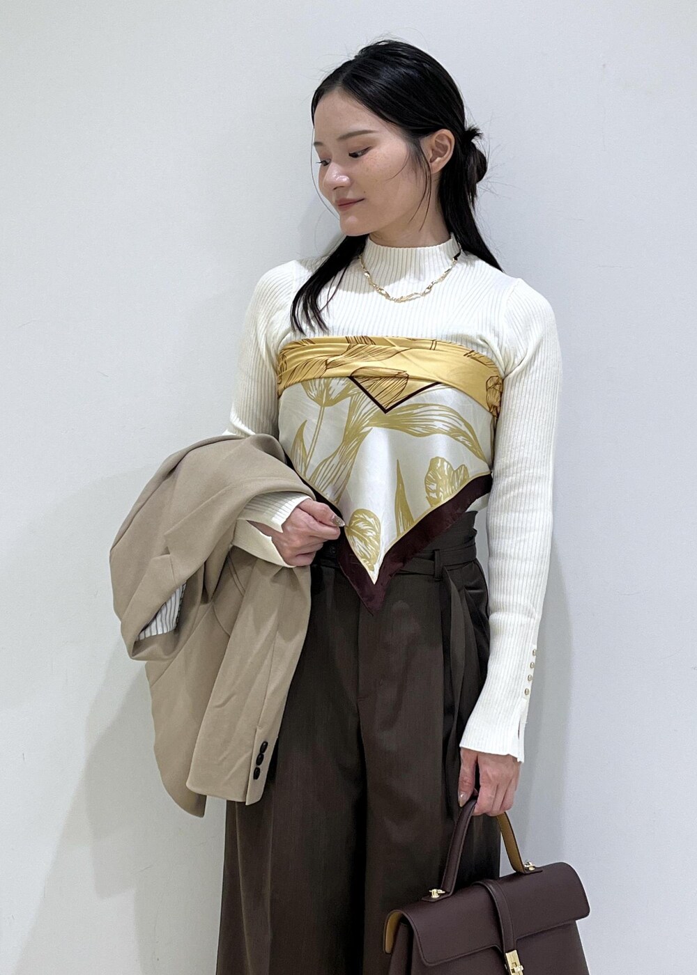 ブラウン系のハンドバッグ、ホワイト系のパンプス、ホワイト系のニット/セーターを着用したレディースの秋コーディネートの5枚目の写真