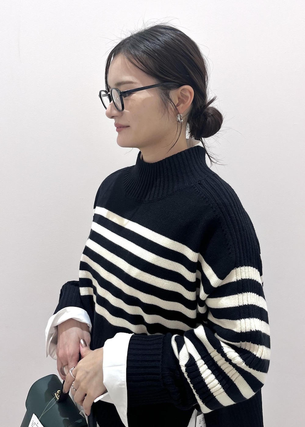 ブラック系のブーツ、ホワイト系のシャツ/ブラウス、ブラック系のニット/セーターを着用したレディースの秋コーディネートの8枚目の写真