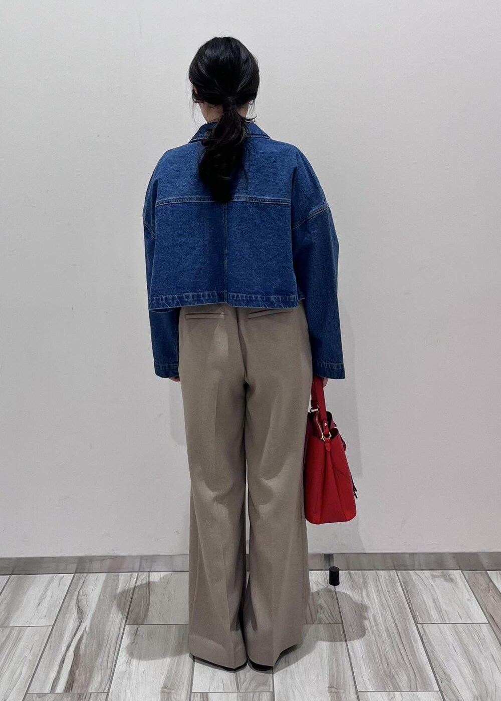 ブルー系のデニムジャケット、ホワイト系のニット/セーター、ベージュ系のスラックスを着用したレディースの冬コーディネートの4枚目の写真