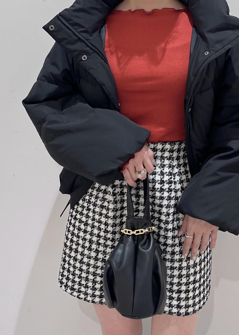 ブラック系のブーツ、ブラック系のスカート、ブラック系のダウンジャケット/コートを着用したレディースの冬コーディネートの7枚目の写真