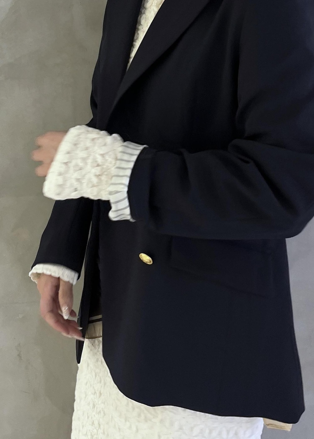 ブラック系のパンプス、ホワイト系のワンピース、ブルー系のテーラードジャケットを着用したレディースの春コーディネートの9枚目の写真