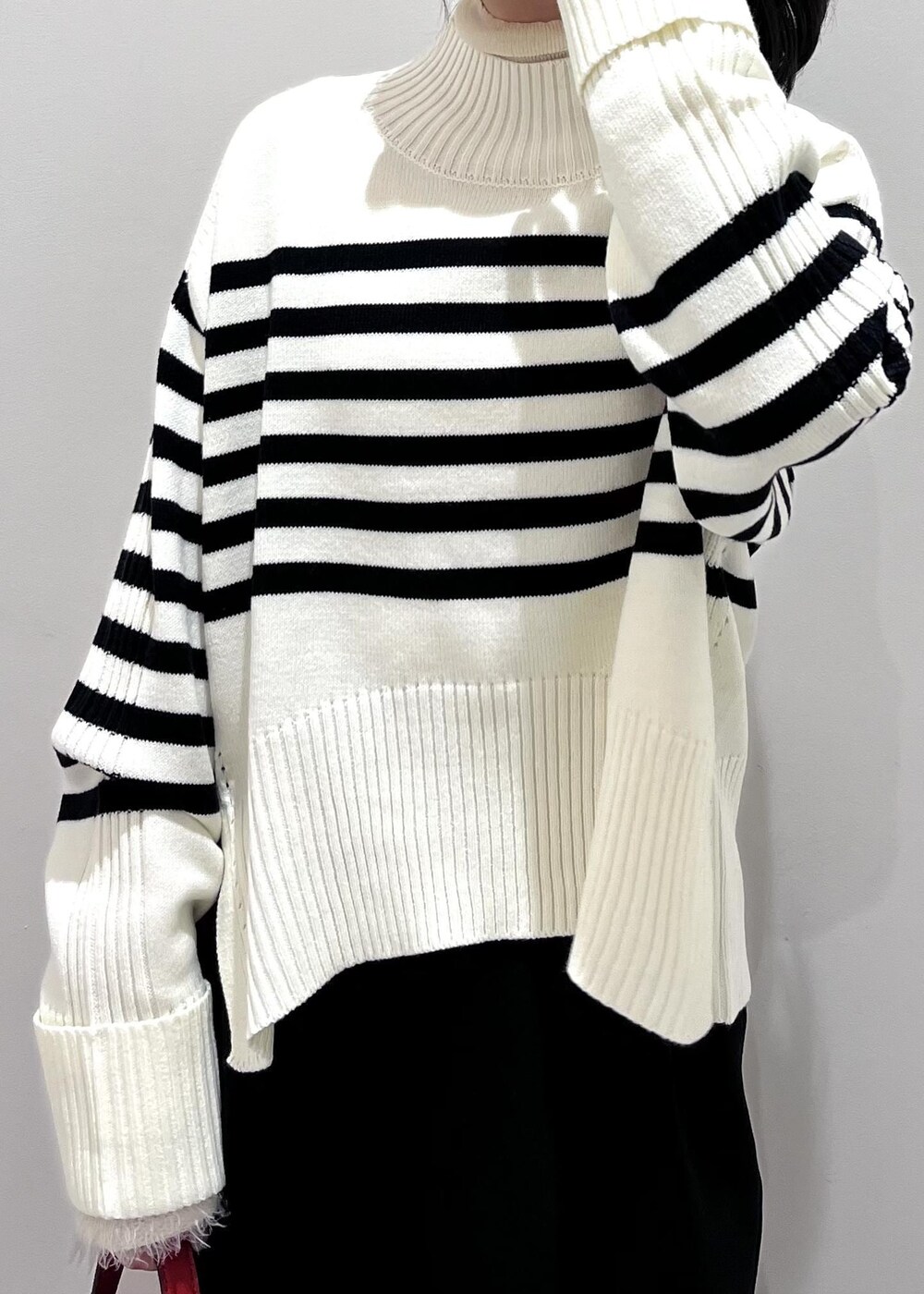 ブラック系のパンプス、ホワイト系のニット/セーター、ホワイト系のニット/セーターを着用したレディースの冬コーディネートの6枚目の写真