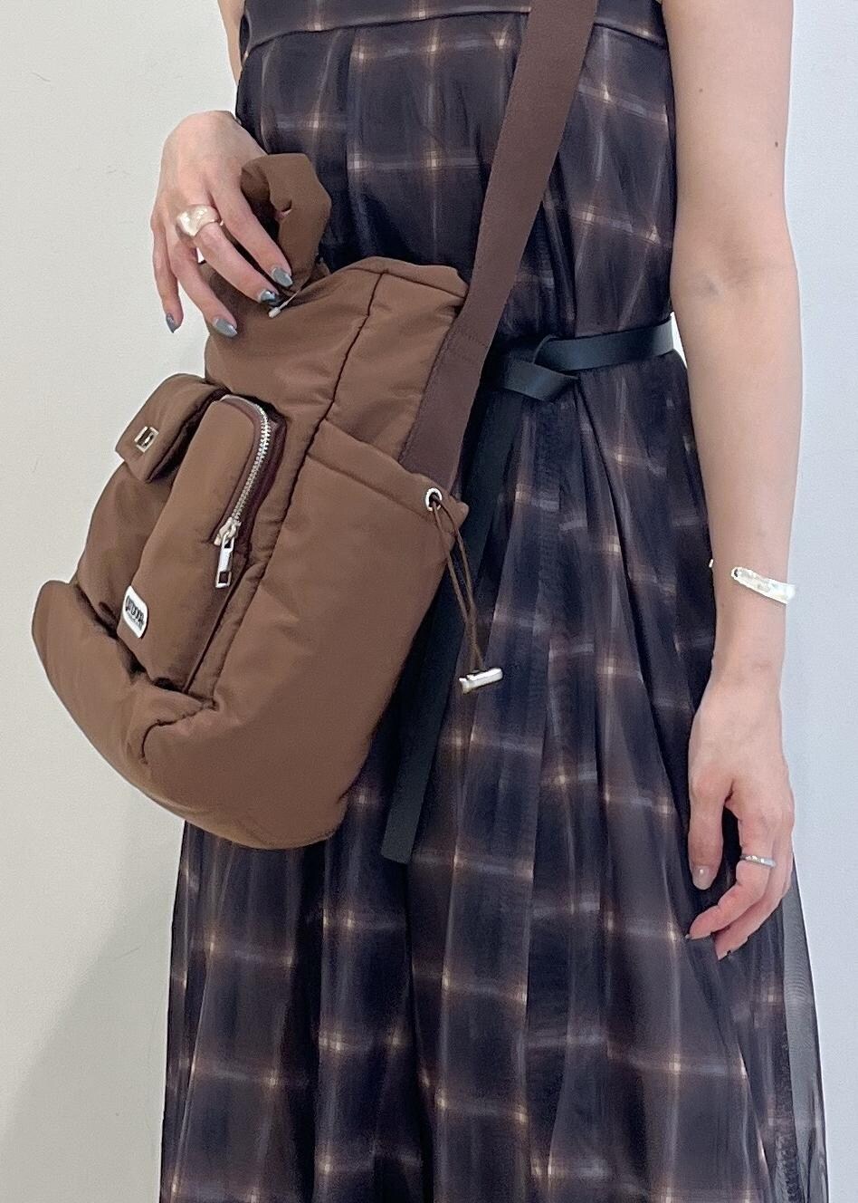 ブルー系のデニムパンツ、ブラウン系のスカート、ブラウン系のキャミソールを着用したレディースの夏コーディネートの6枚目の写真