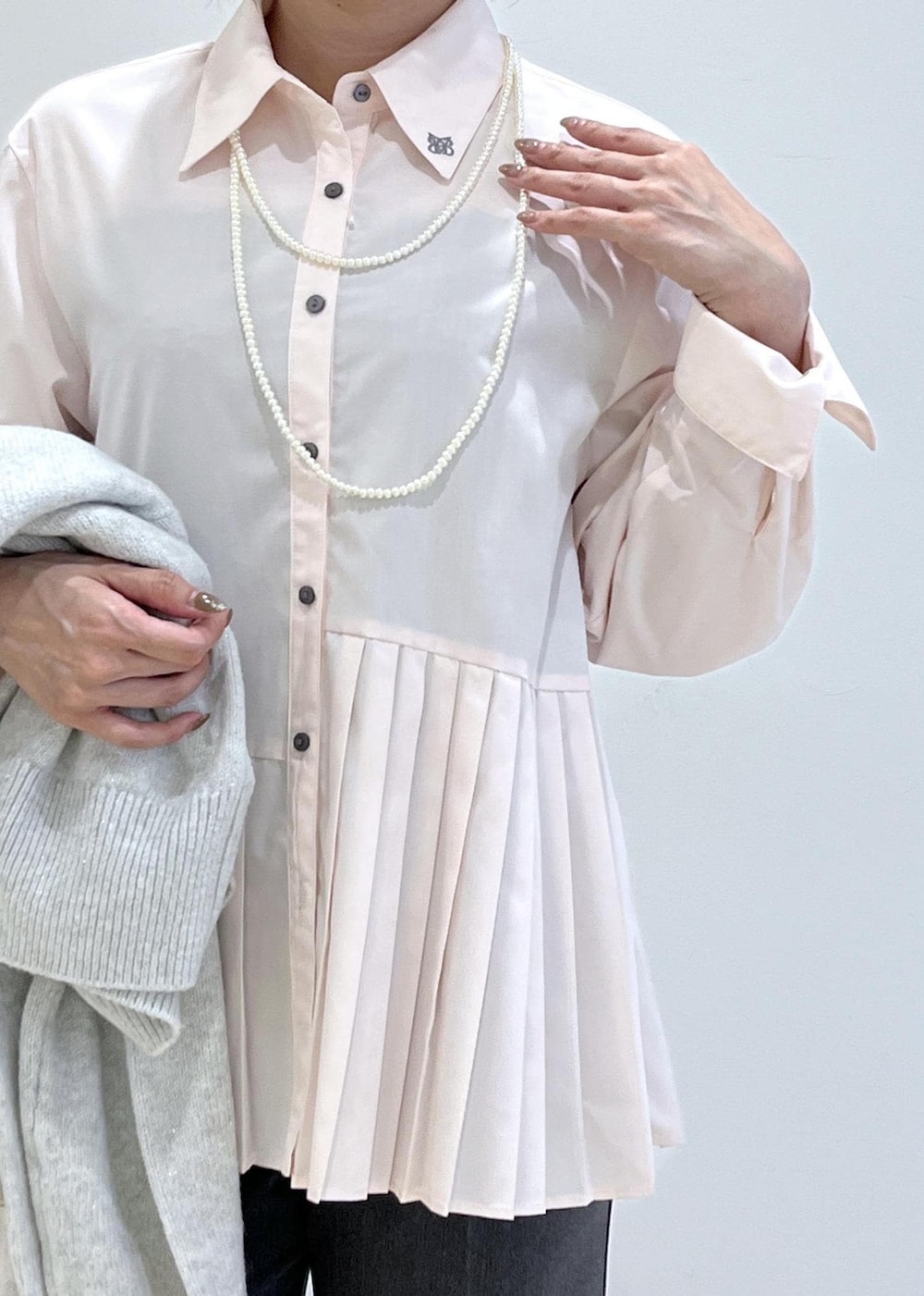 ホワイト系のショルダーバッグ、ホワイト系のパンプス、グレー系のスラックスを着用したレディースの秋コーディネートの5枚目の写真