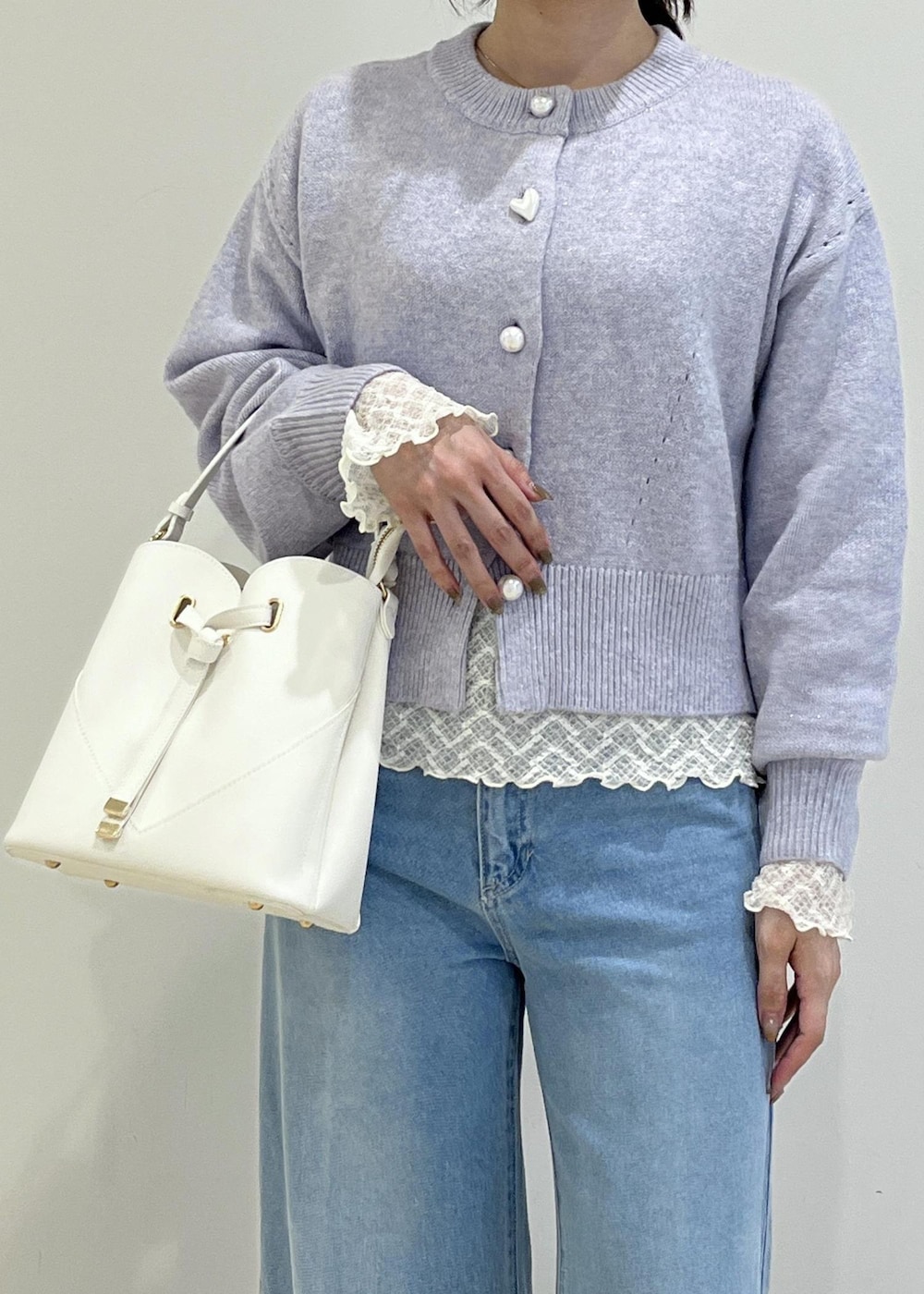 ホワイト系のショルダーバッグ、ホワイト系のパンプス、パープル系のカーディガン/ボレロを着用したレディースの秋コーディネートの7枚目の写真