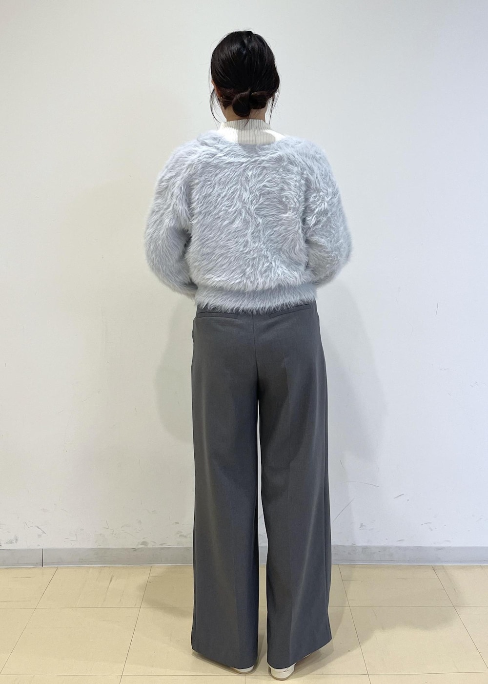 グレー系のスラックス、ホワイト系のパンプス、ブルー系のカーディガン/ボレロを着用したレディースの秋コーディネートの3枚目の写真