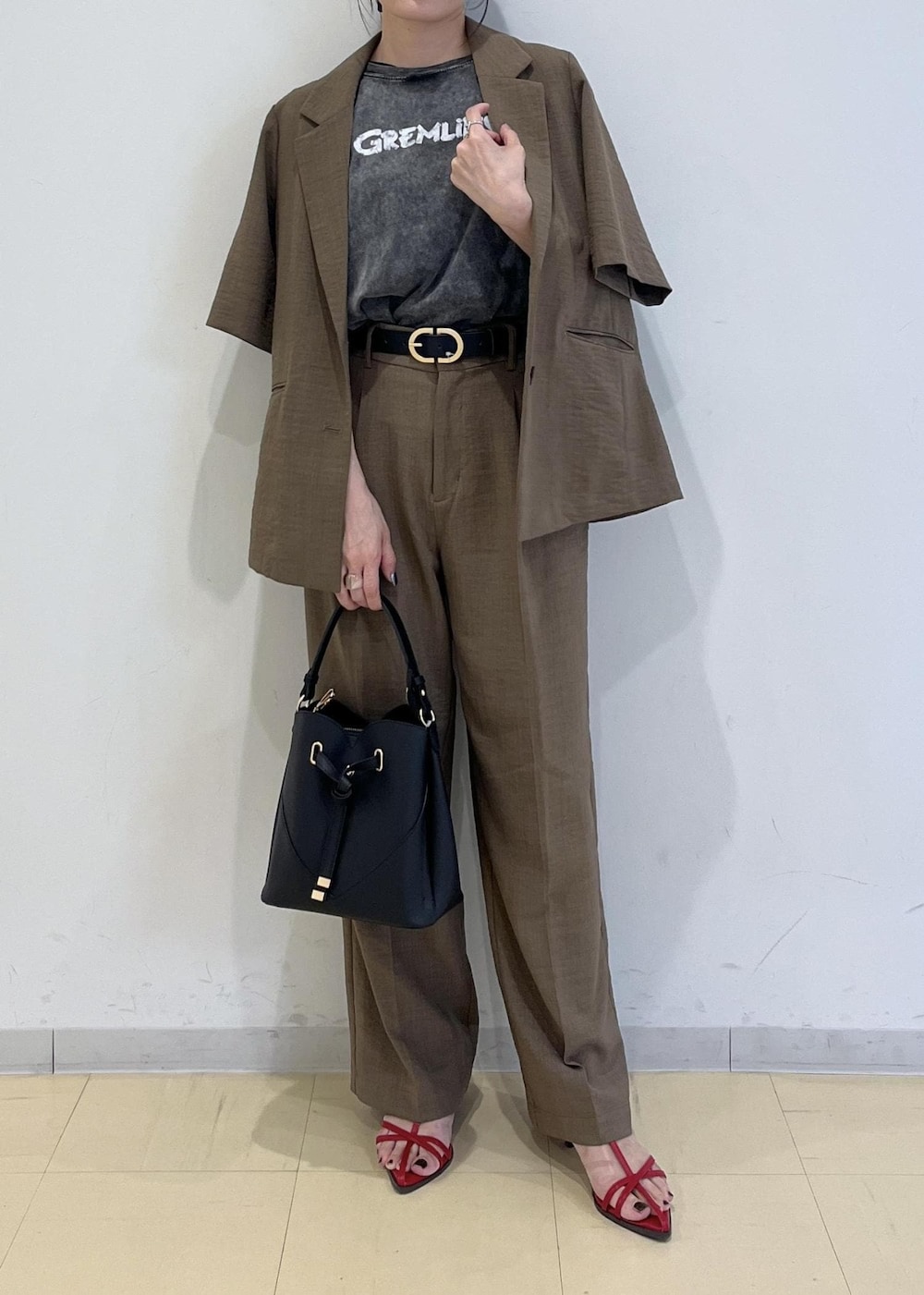 ブラック系のショルダーバッグ、レッド系のサンダル、ブラック系のTシャツ/カットソーを着用したレディースの夏コーディネートの2枚目の写真