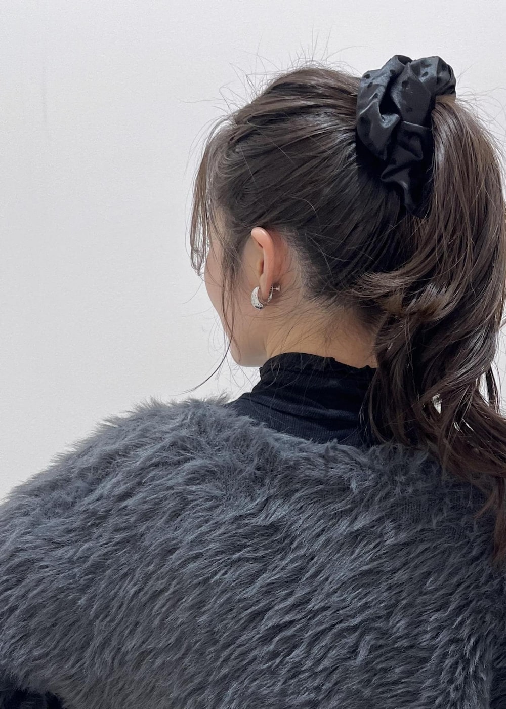 ブラウン系のショルダーバッグ、ブラック系のスラックス、グレー系のカーディガン/ボレロを着用したレディースの冬コーディネートの8枚目の写真