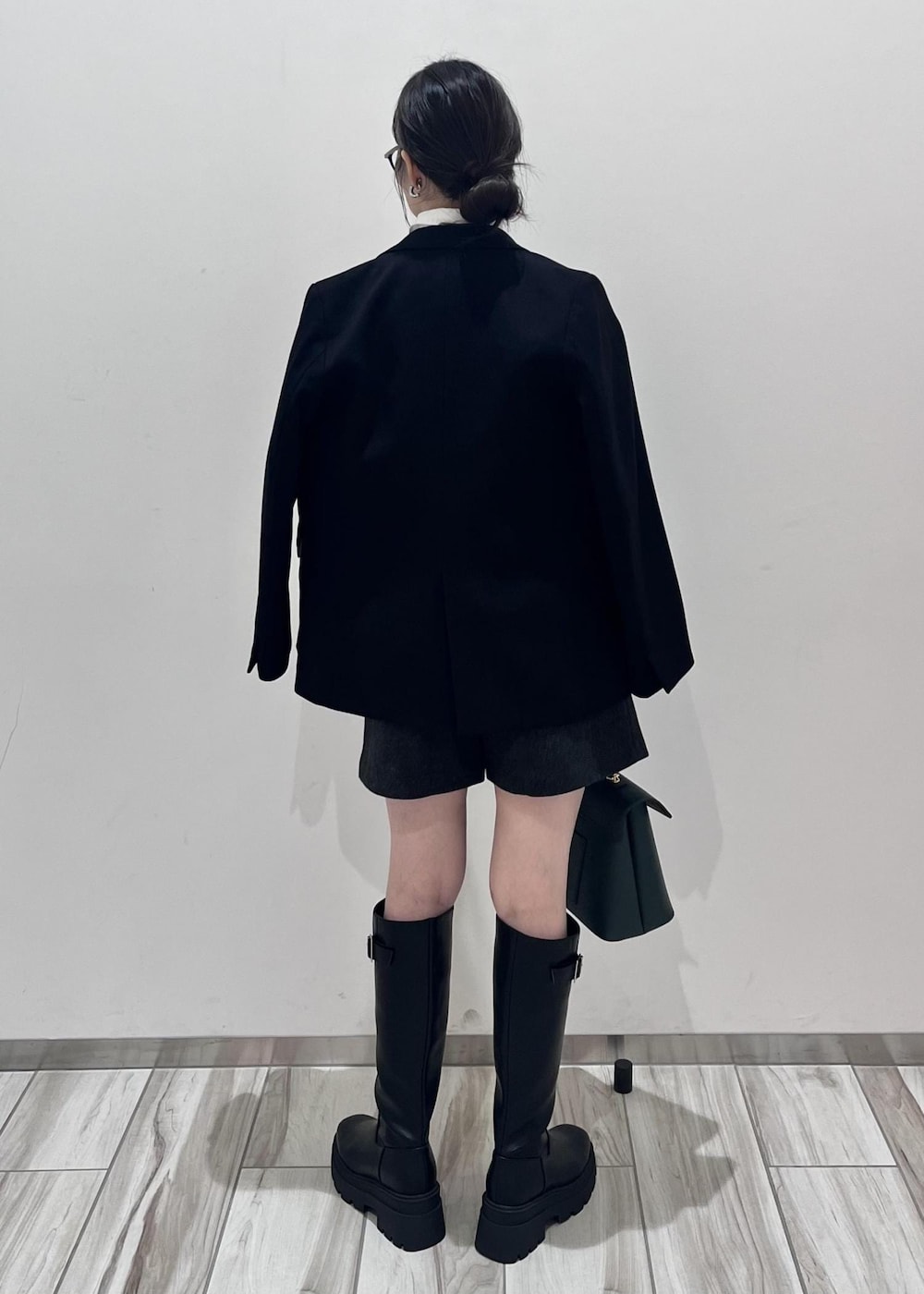 ブラック系のブーツ、ホワイト系のシャツ/ブラウス、ブラック系のニット/セーターを着用したレディースの秋コーディネートの2枚目の写真