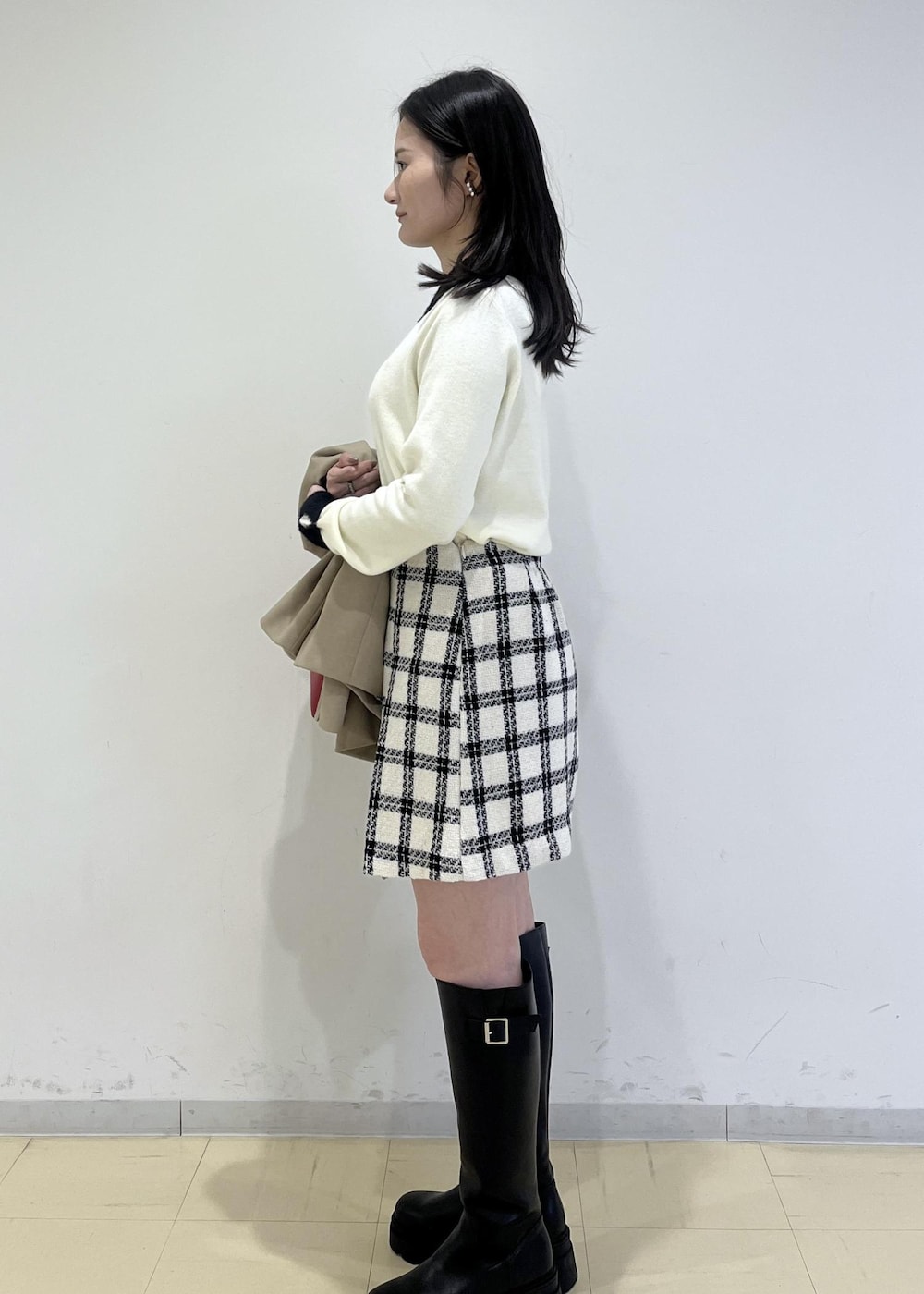ブラック系のブーツ、ホワイト系のスカート、ホワイト系のニット/セーターを着用したレディースの冬コーディネートの5枚目の写真